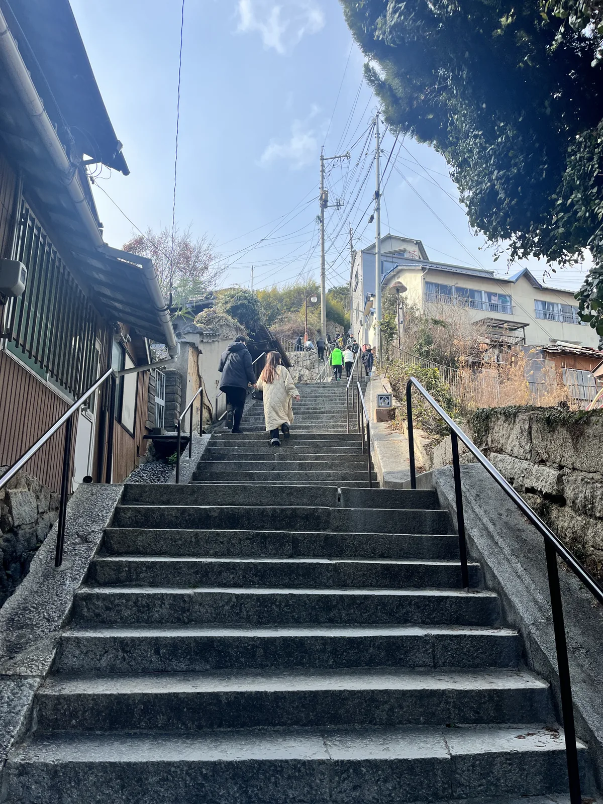 A second flight of stone steps continuing the climb up Senkoji-yama with morning sun and shadows