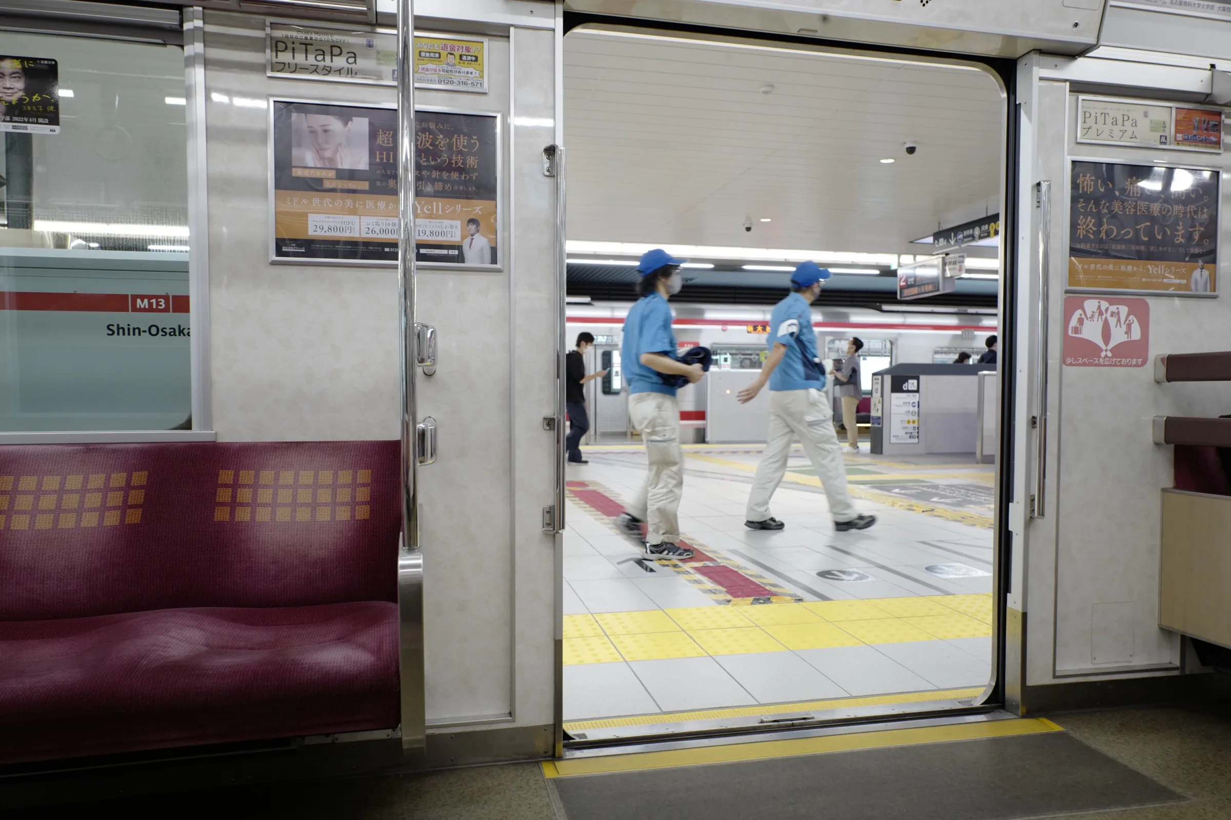 Osaka Metro M13 Shin-Osaka Midosuji Line platform with doors open showing station workers