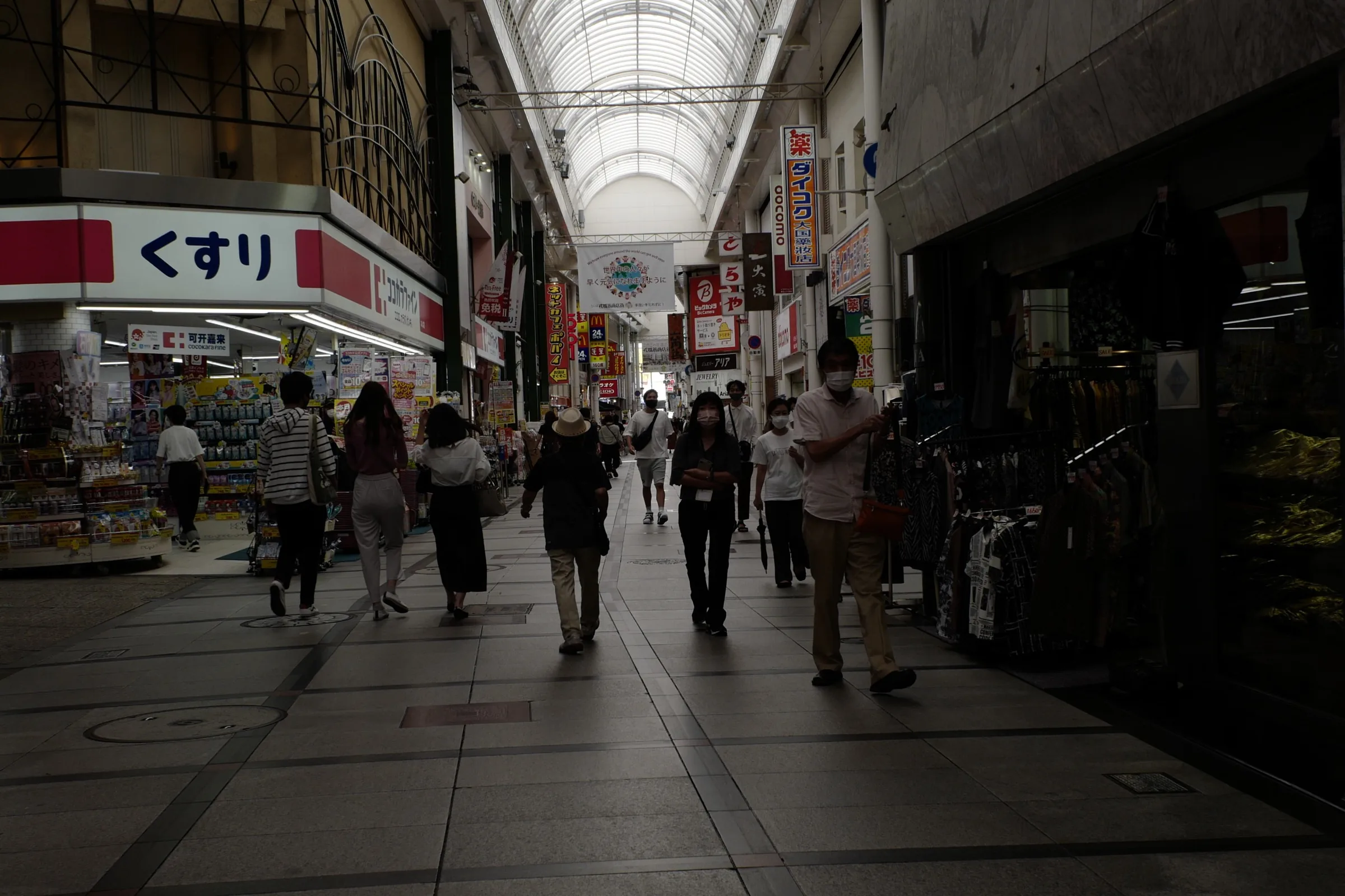 Covered Shinsaibashi-suji shopping arcade in Osaka with shoppers and drugstore signage