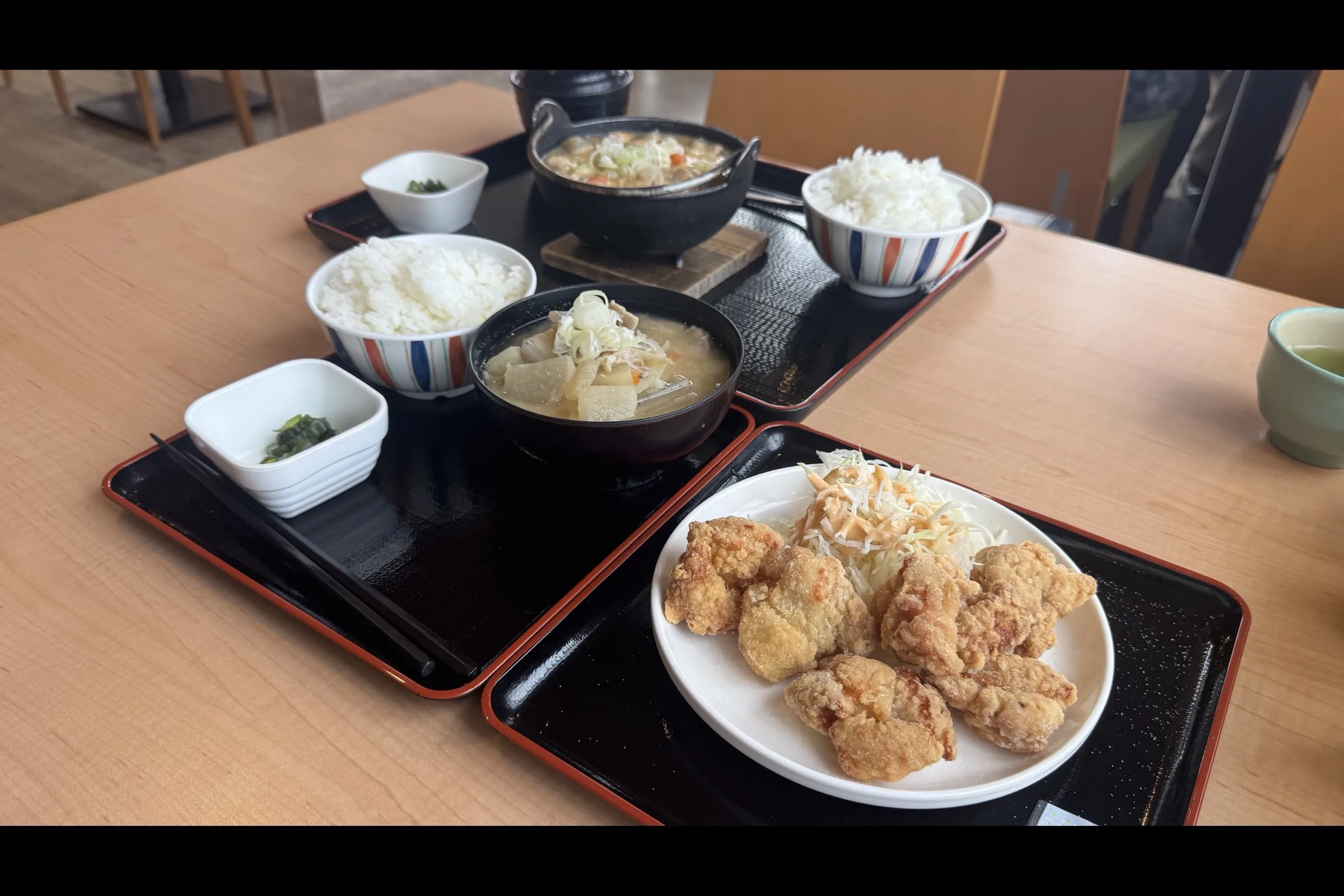 Motsu-nikomi hot pot, tonjiru set, and karaage plate laid out at Restaurant Fujioyama