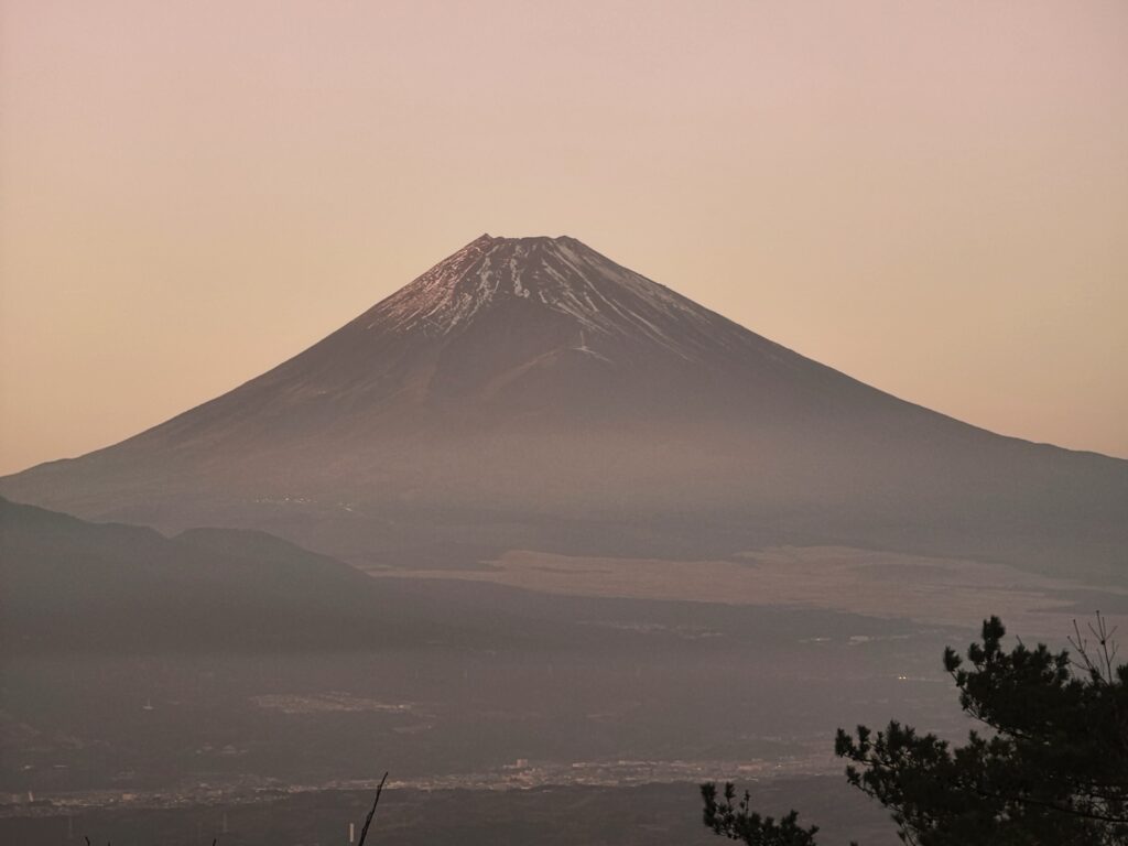 Mt Fuji fading into golden summer haze with only the snowless summit distinct