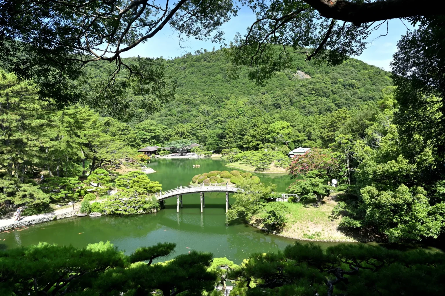 Ritsurin Garden central pond with an arched bridge and Mt Shiun behind it in Takamatsu