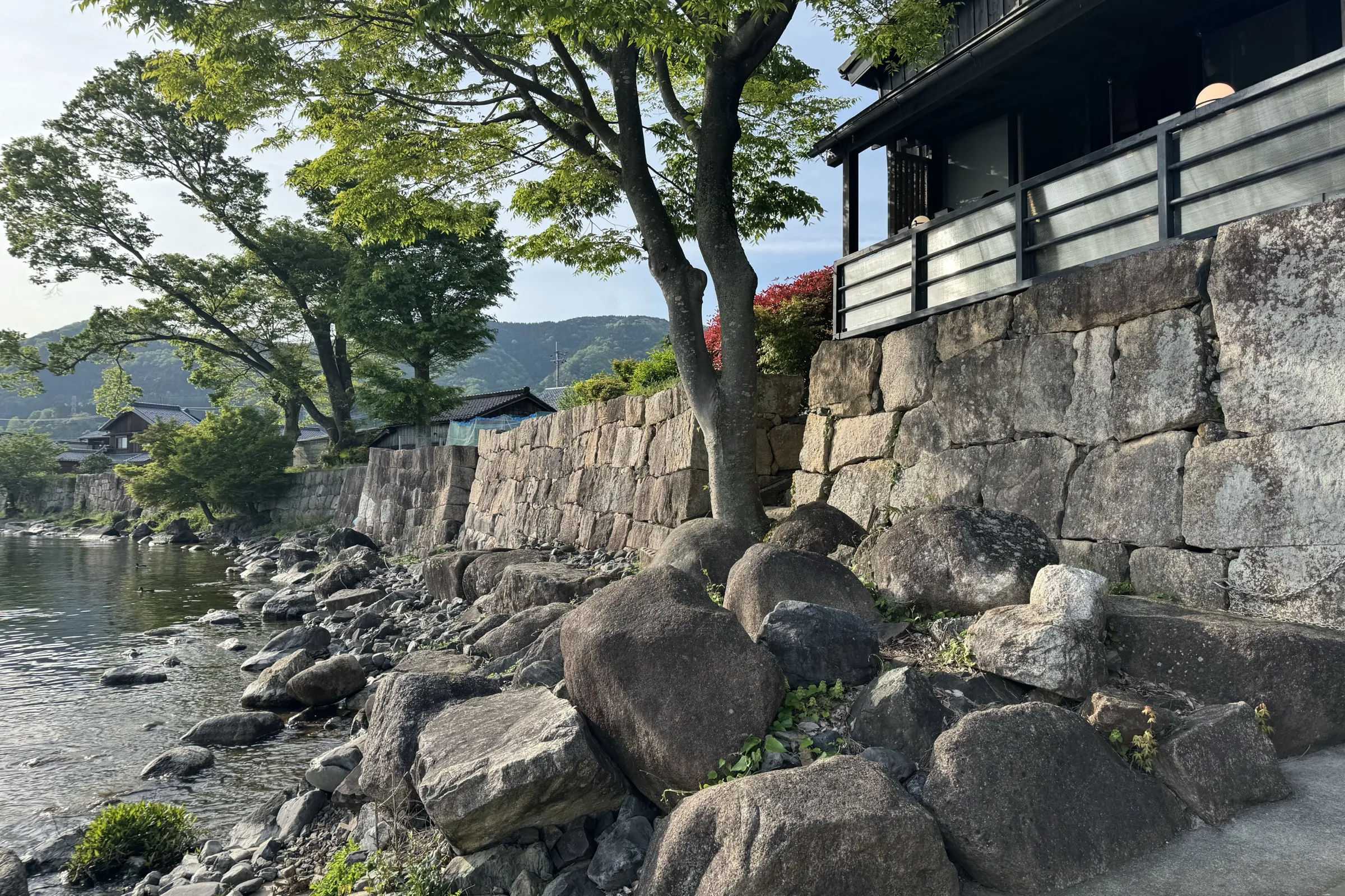 Layered Edo-era stone wall and traditional dark-wood house at Kaizu fishing village on Lake Biwa