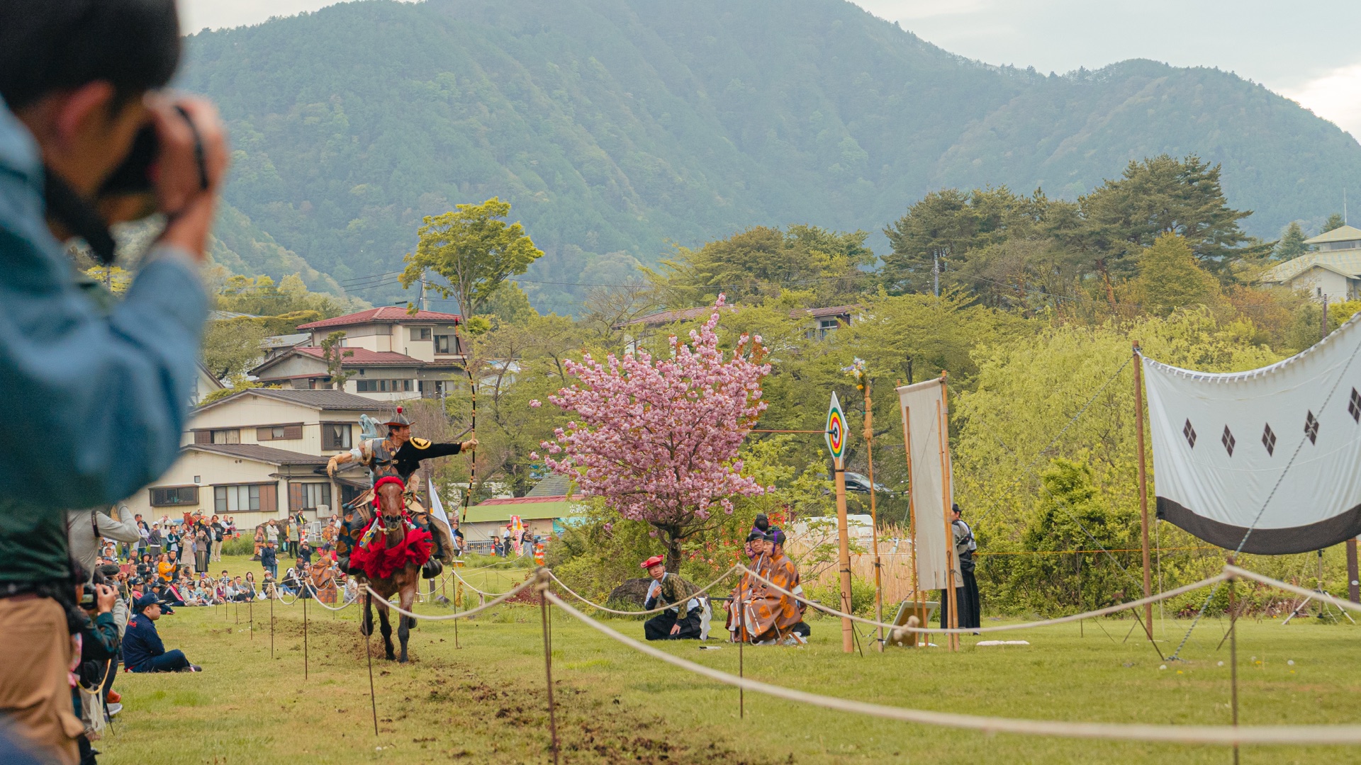Yabusame action photographed from behind a foreground photographer