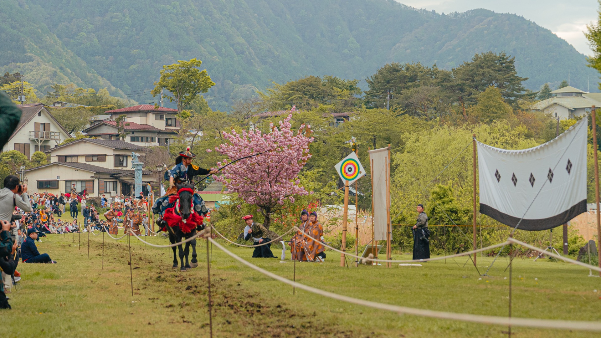 Yabusame archer lowering bow toward the round target