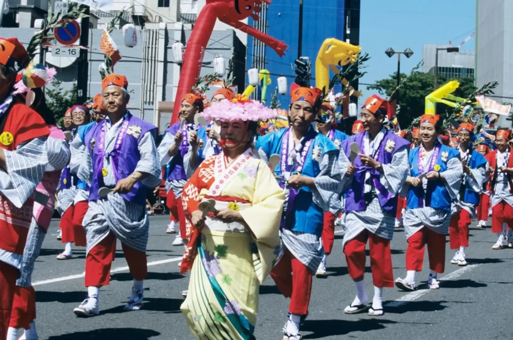 Colorful dancers in traditional costumes parading through the streets of Fukuoka during the Hakata Dontaku Festival, one of Japan's largest Golden Week celebrations.
