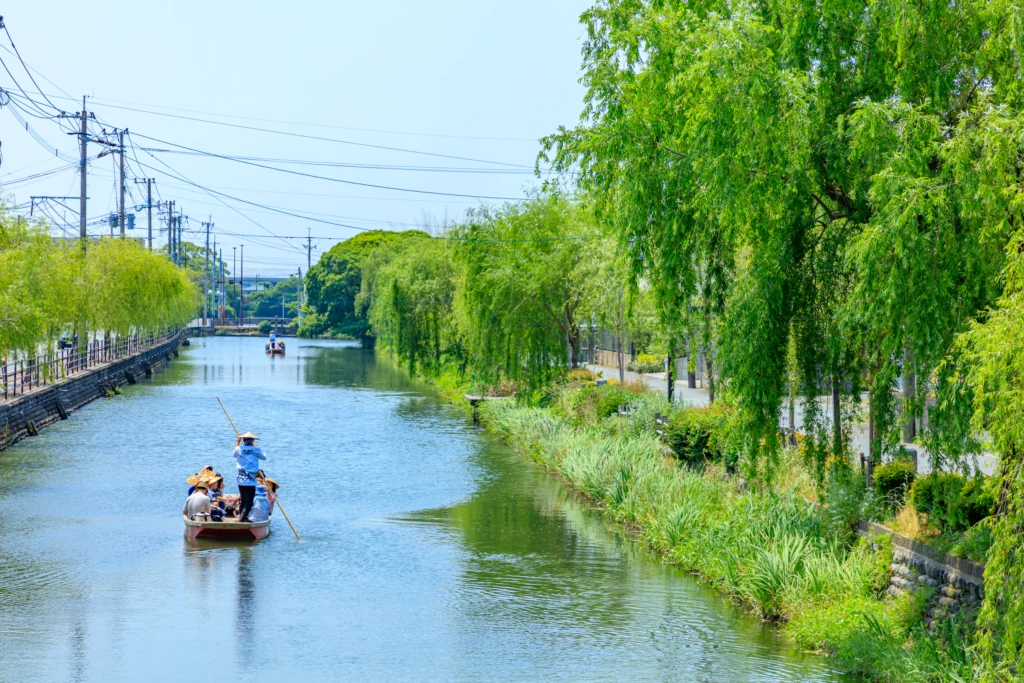 Traditional punting boat on Yanagawa canal with willow trees in Fukuoka