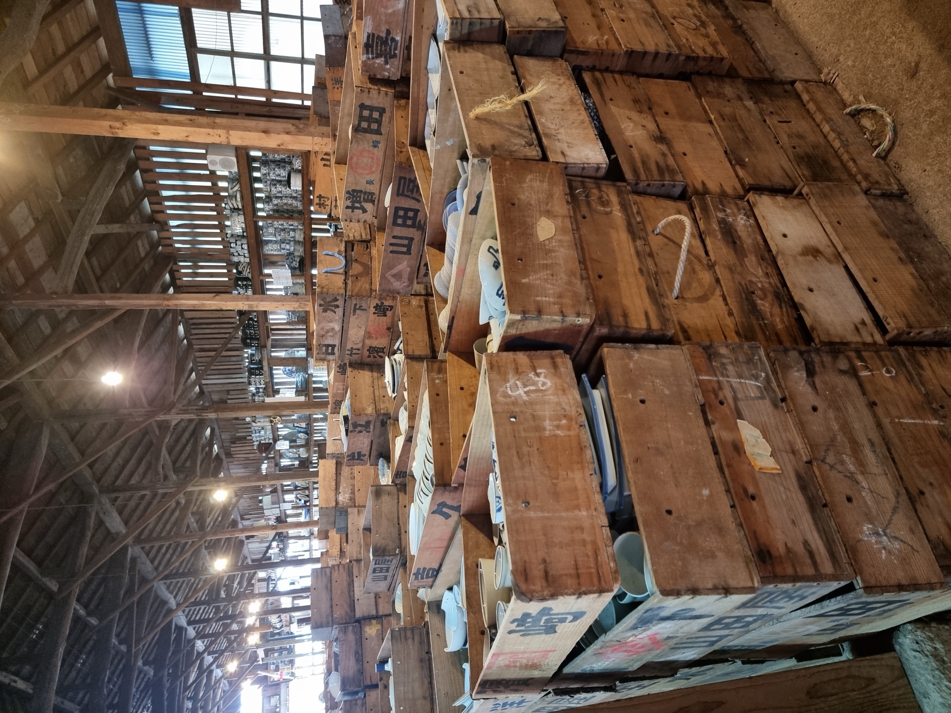 Inside the Kouraku-gama warehouse with rows of wooden crates and pottery