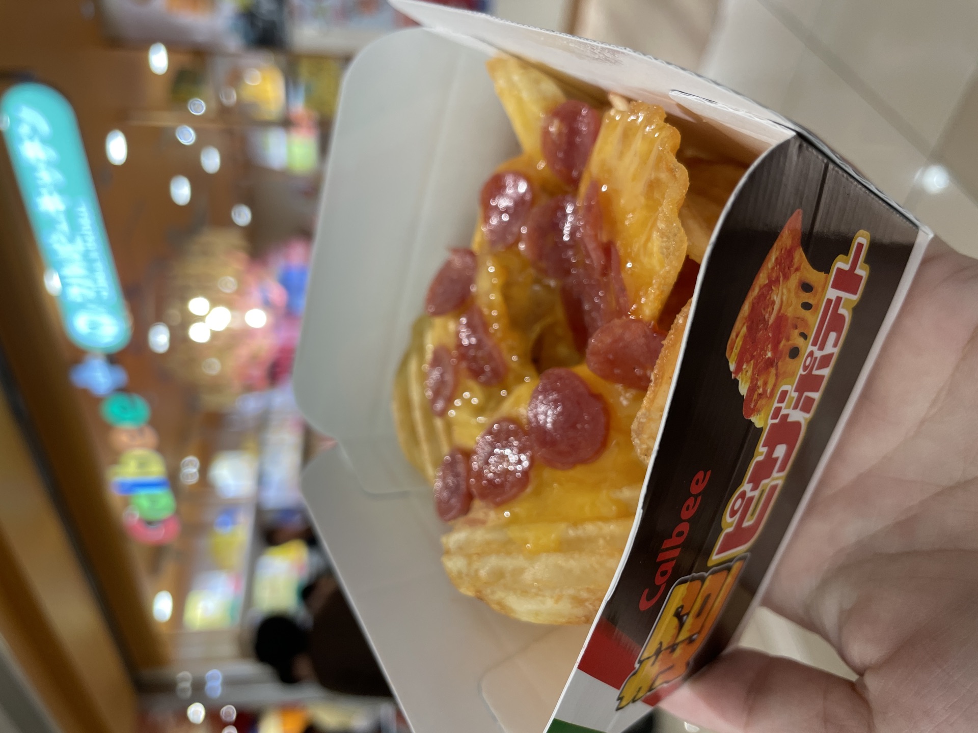 Hot Pizza Potato closeup with cheese pepperoni topping in Calbee box
