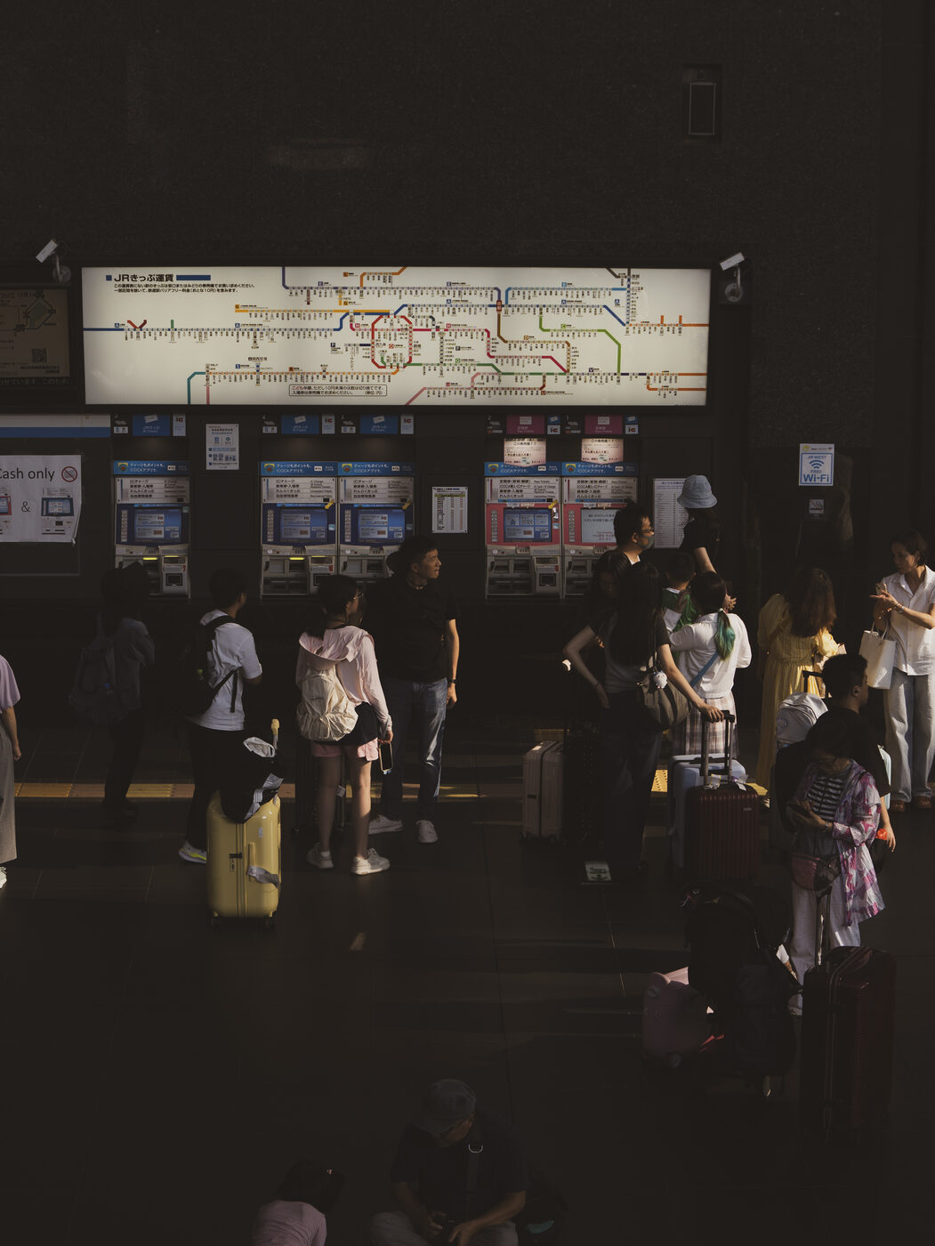 Kyoto Station JR platform with timetable boards in low evening light, sparse crowd