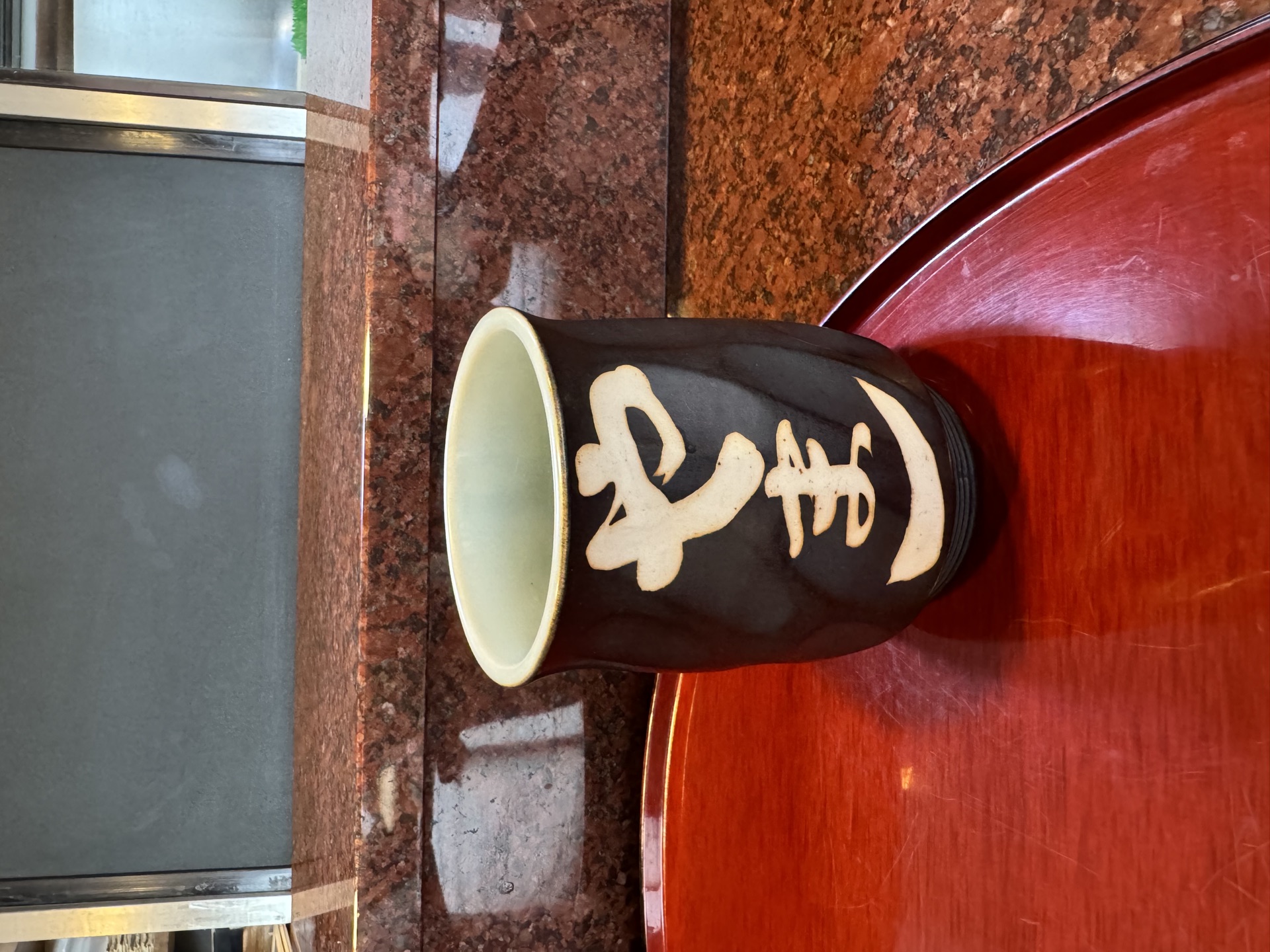 Yama-ichi yunomi tea cup with shop name brush-painted in white on black glaze