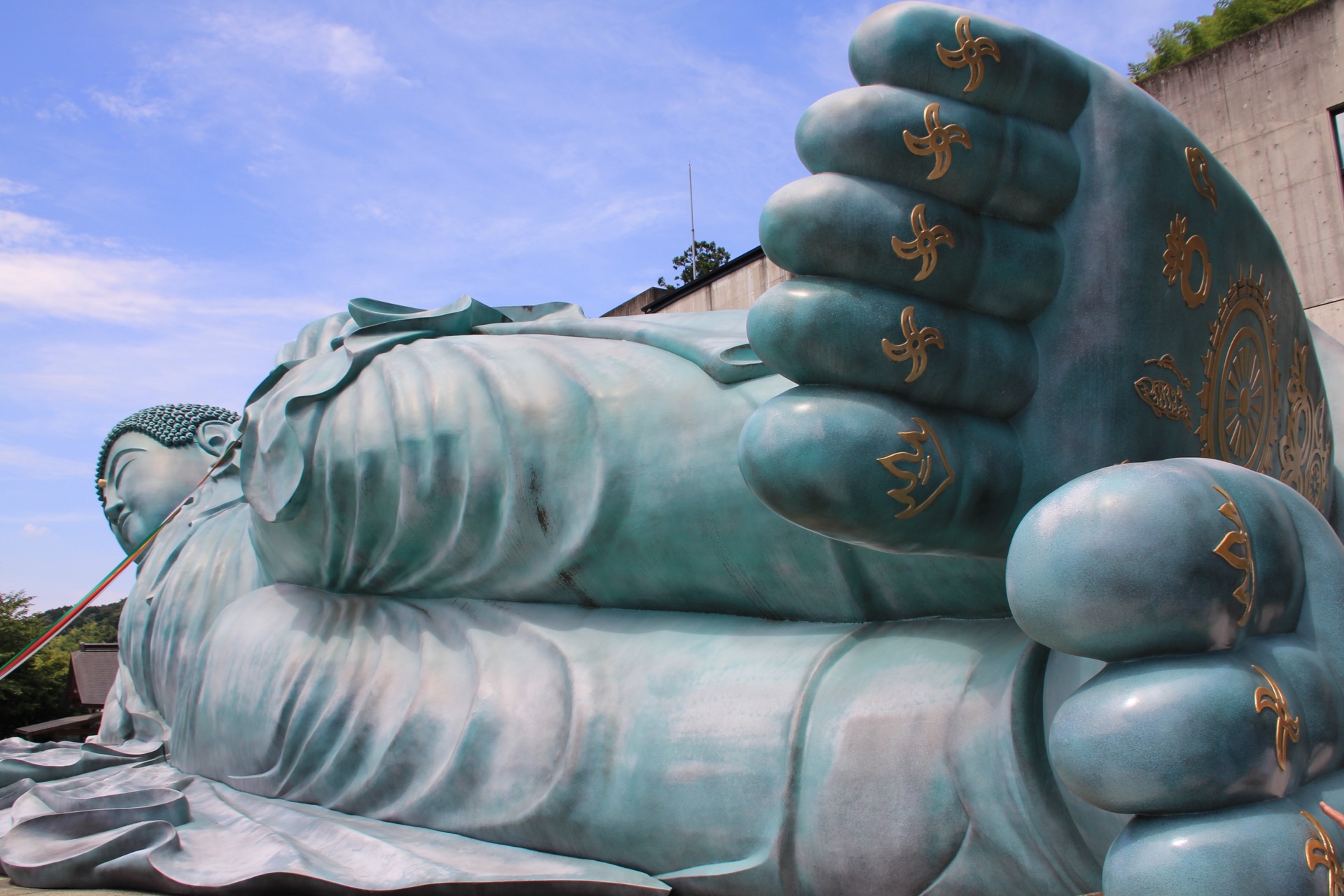 Detailed view of the Nanzoin Reclining Buddha's foot showing gold spiral patterns wheel of dharma and Sanskrit characters
