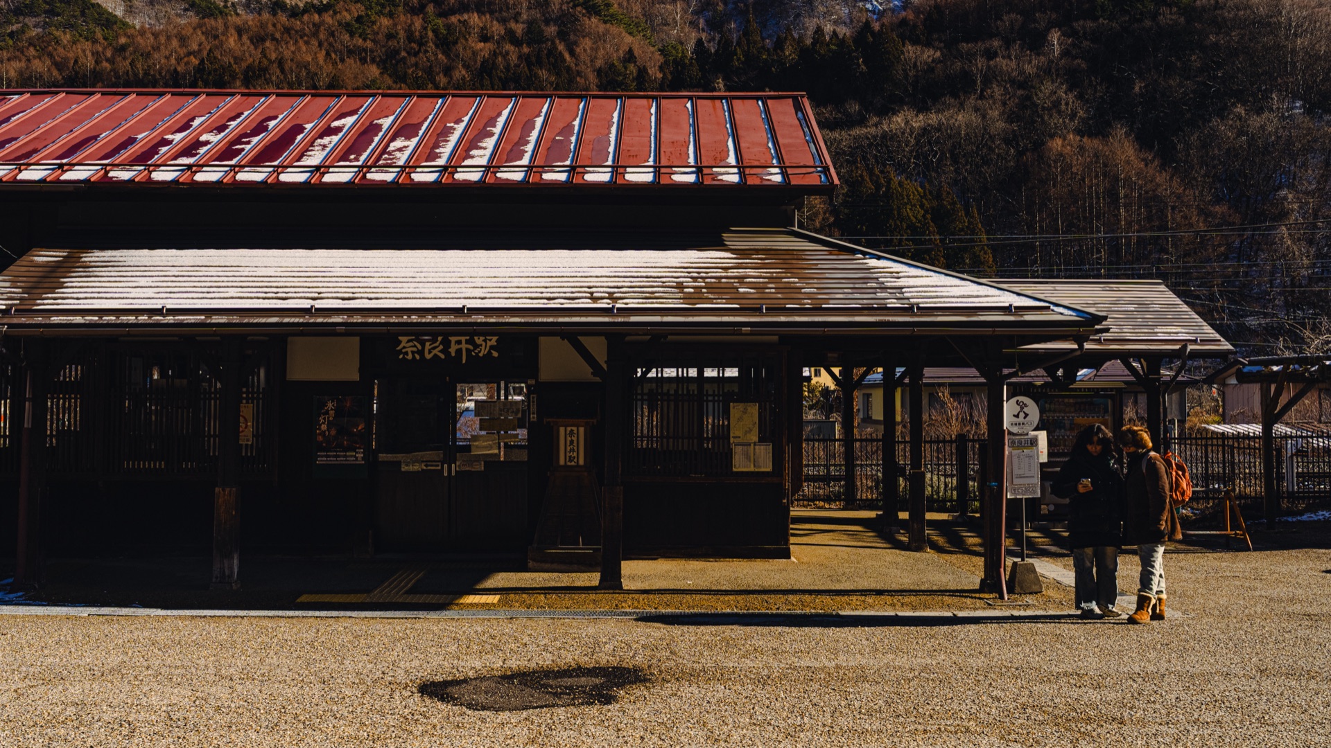 The vintage JR Narai station building in winter with red metal roof and platform shelter