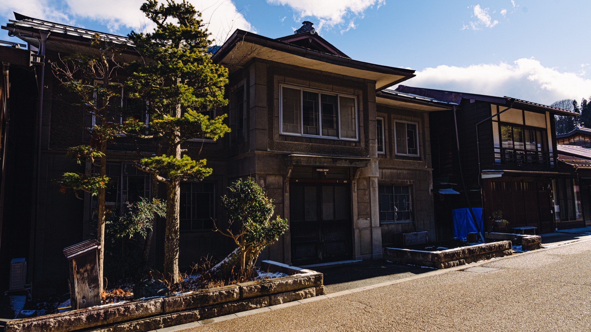 A Taisho-era stone-faced house in Naraijuku with bonsai trees and a side ryokan