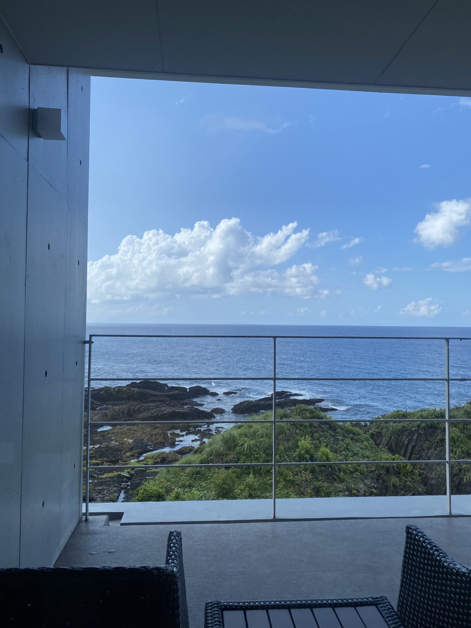 Private terrace with wicker furniture overlooking the Yakushima coastline
