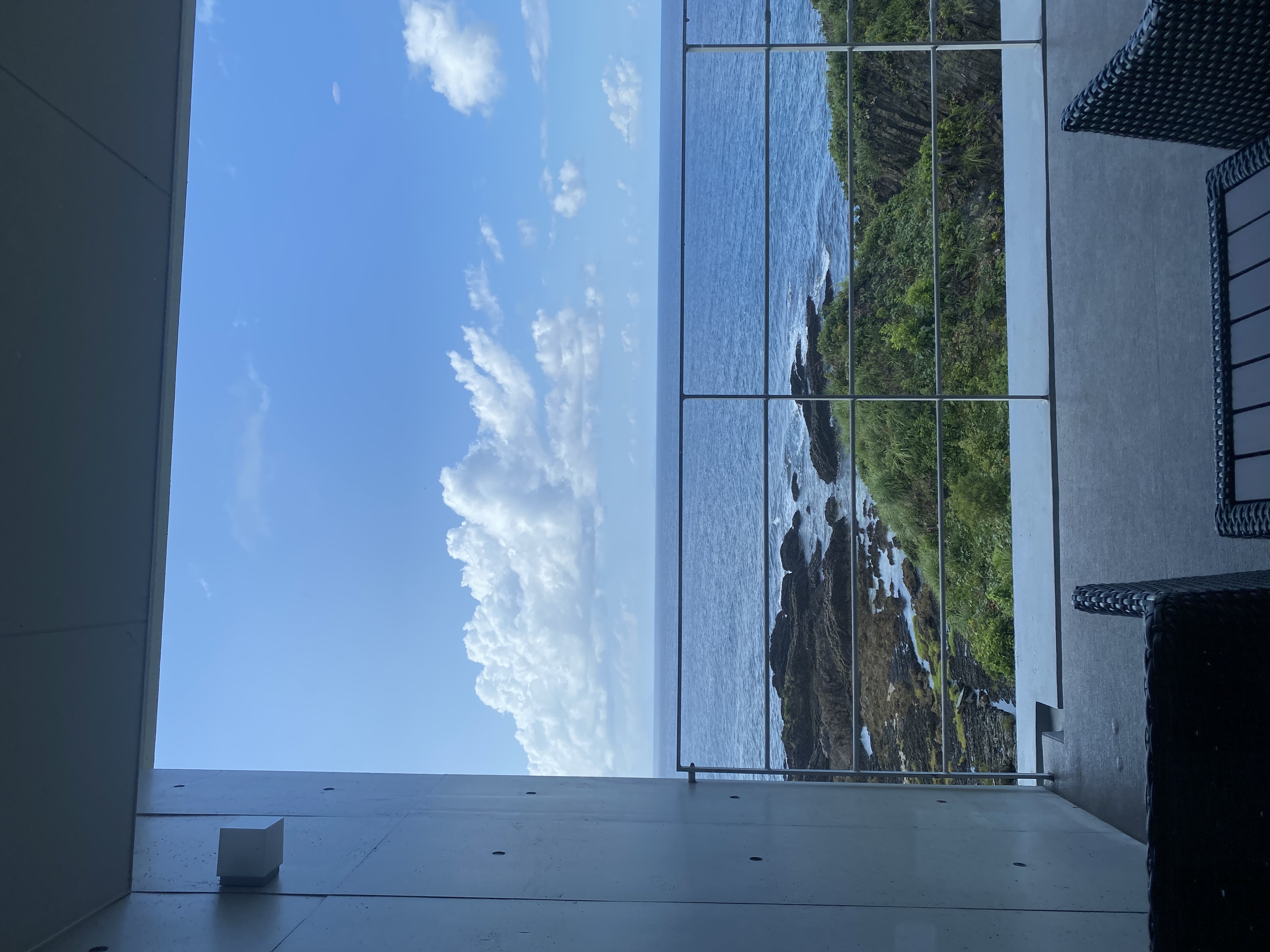 Private terrace with wicker furniture overlooking the Yakushima coastline