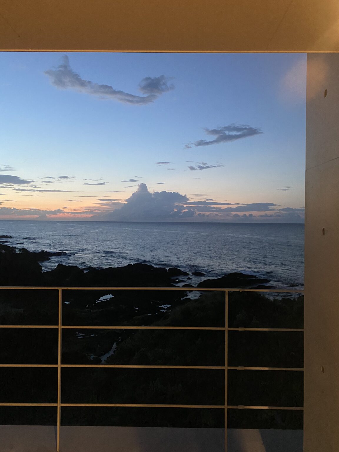 Sea-facing deck view at sunset over the rocky Yakushima north shore