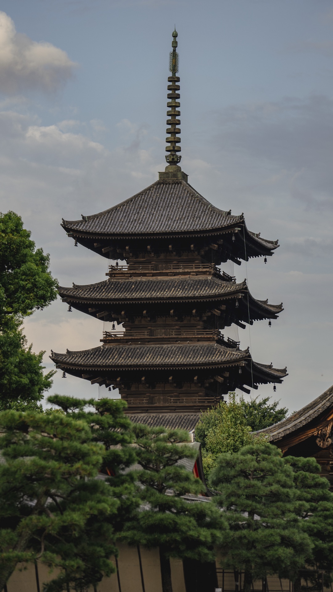 Vertical view of Toji's five-story pagoda showing all five tiers and the spire against a soft cloudy sky