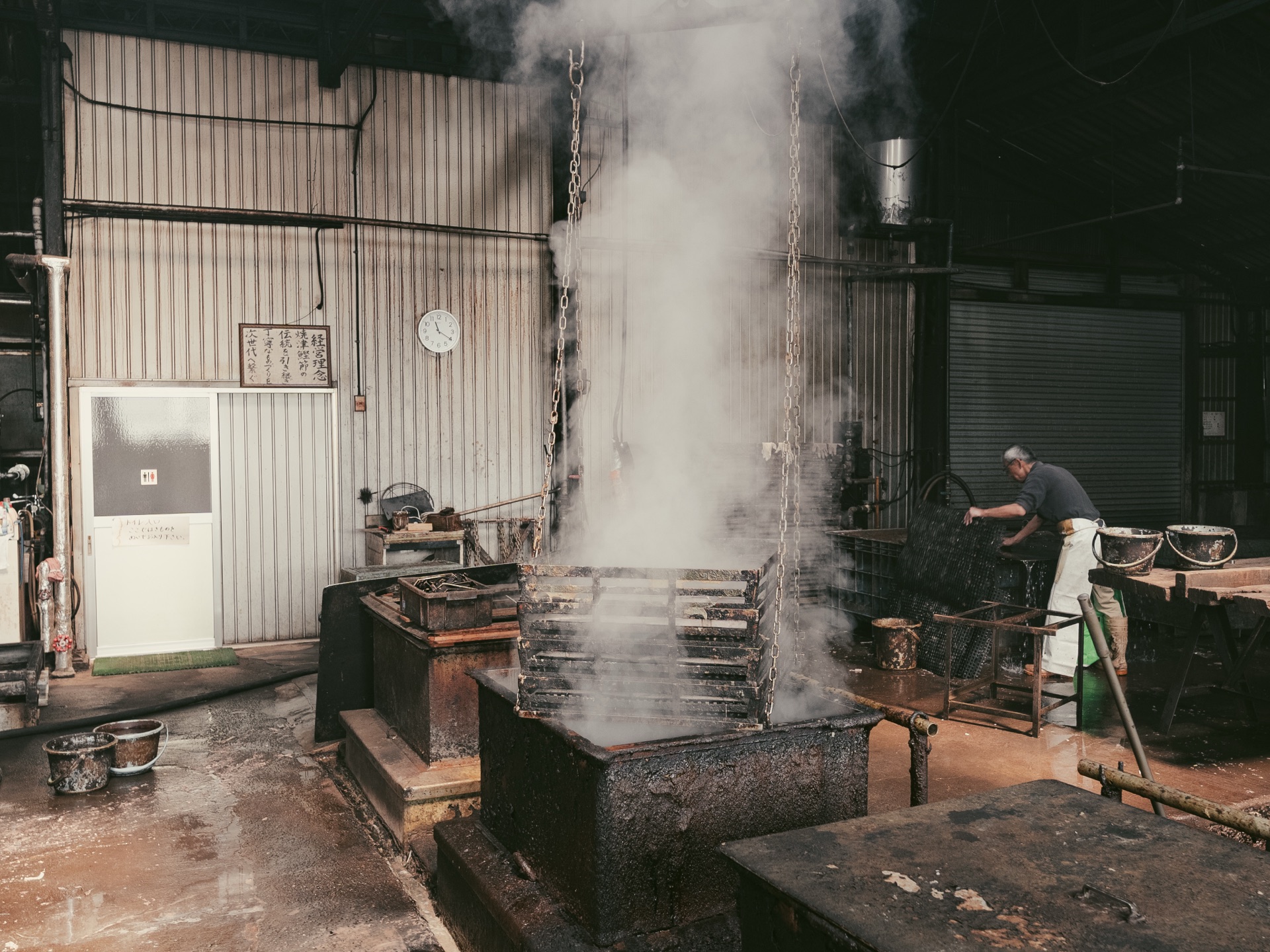 A steaming station at Yamaju with thick white steam rising into the rafters of the wooden factory