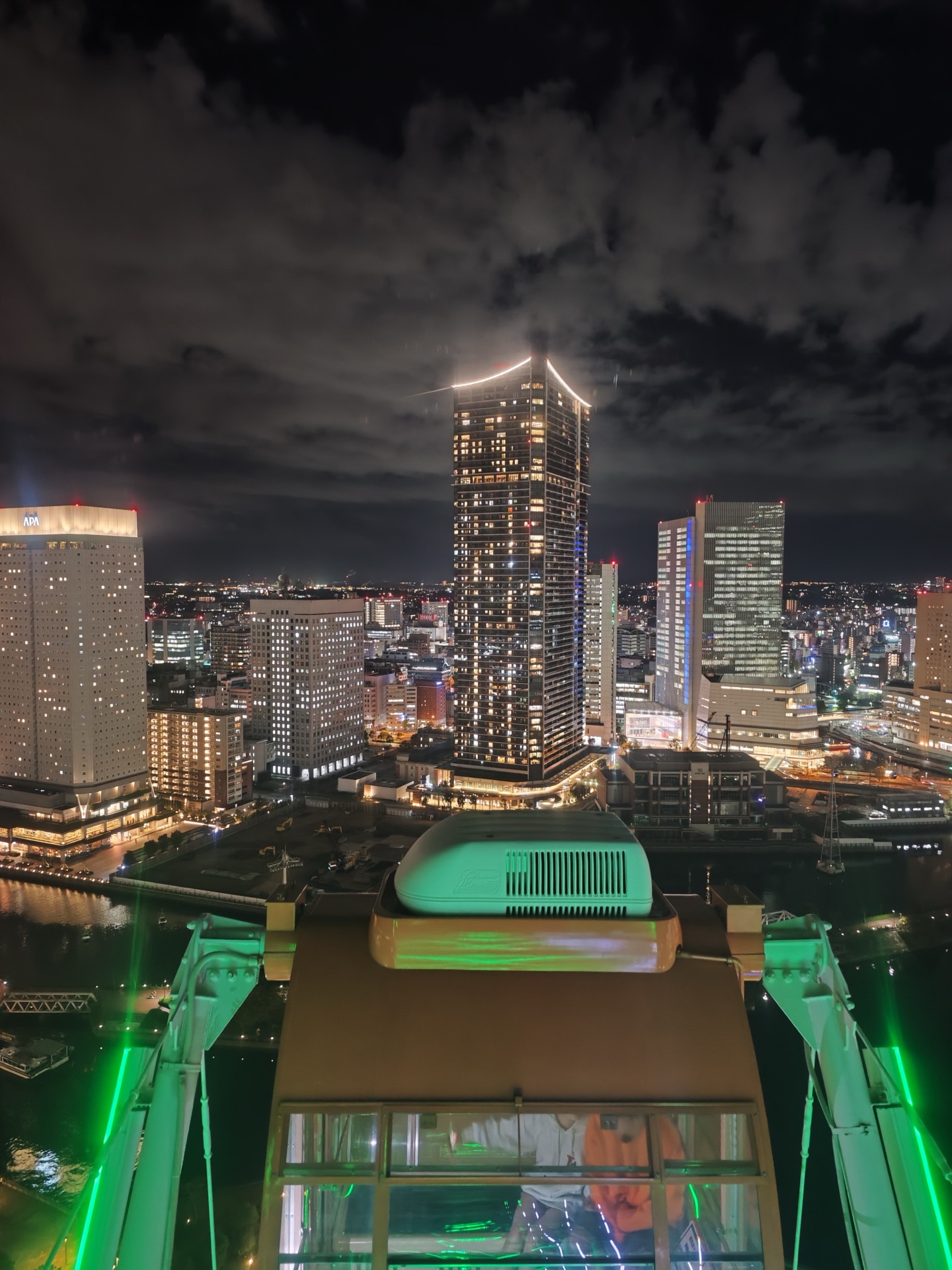 View from inside Cosmo Clock 21 cabin showing Yokohama Minato Mirai skyline at night with bridge