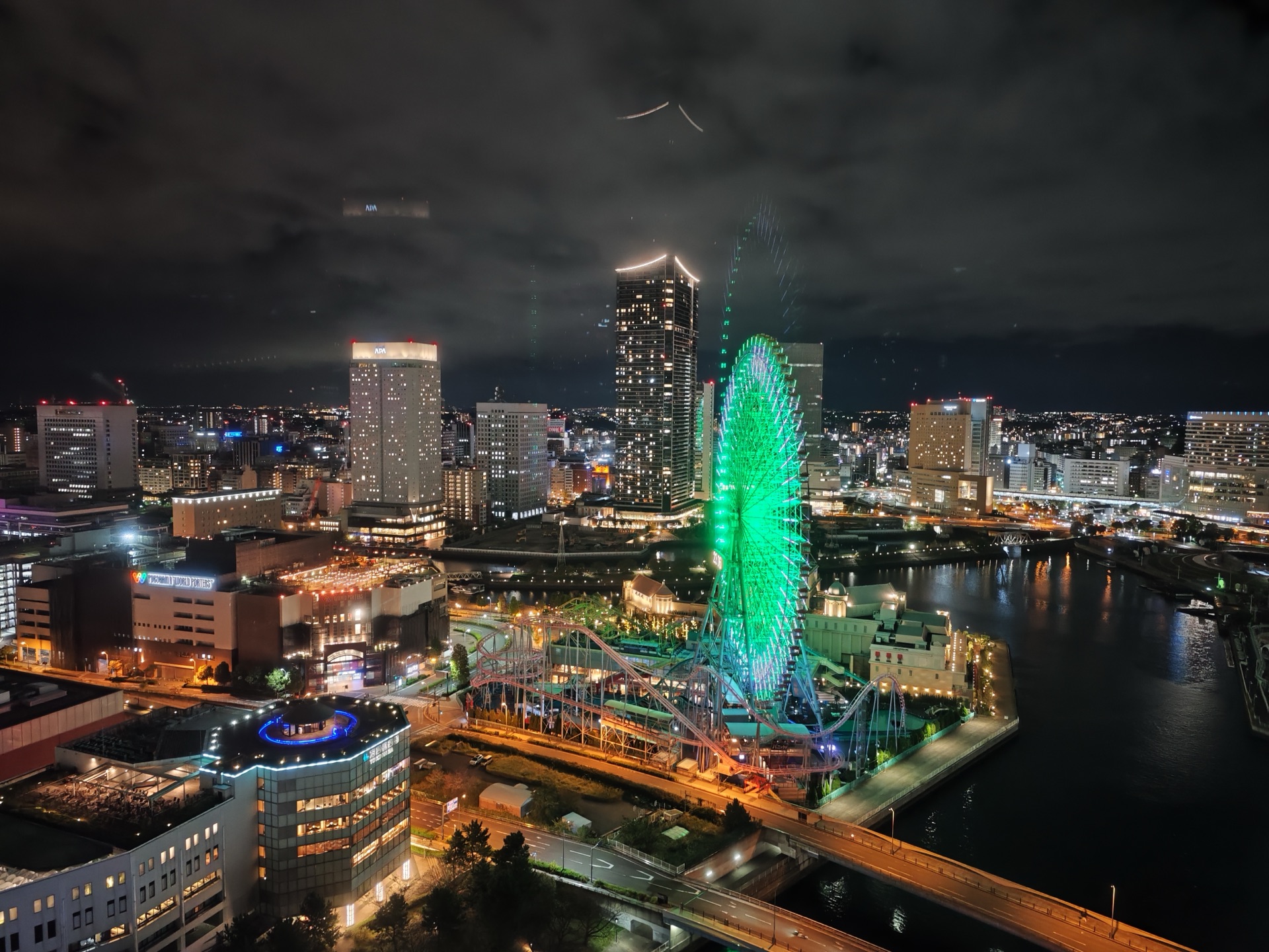 Cosmo Clock 21 illuminated in green from the hotel window late at night