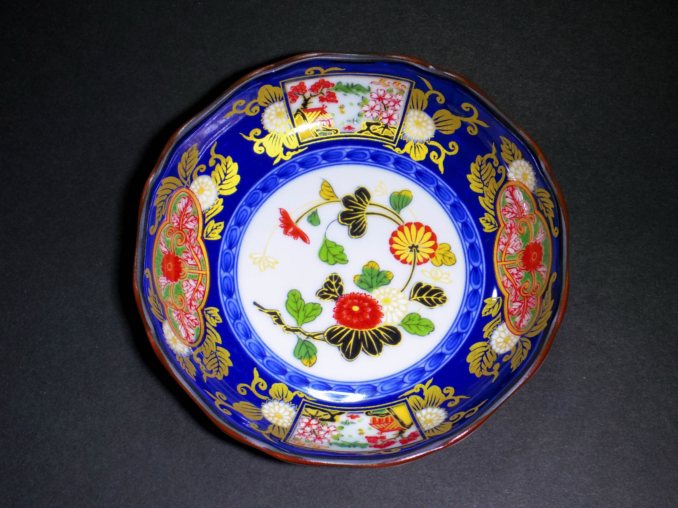 An antique Old Imari (Ko-Imari) porcelain bowl decorated in deep cobalt blue, iron red and gold brocade with chrysanthemum and flower patterns, the classic Hizen export style made in Arita, Saga