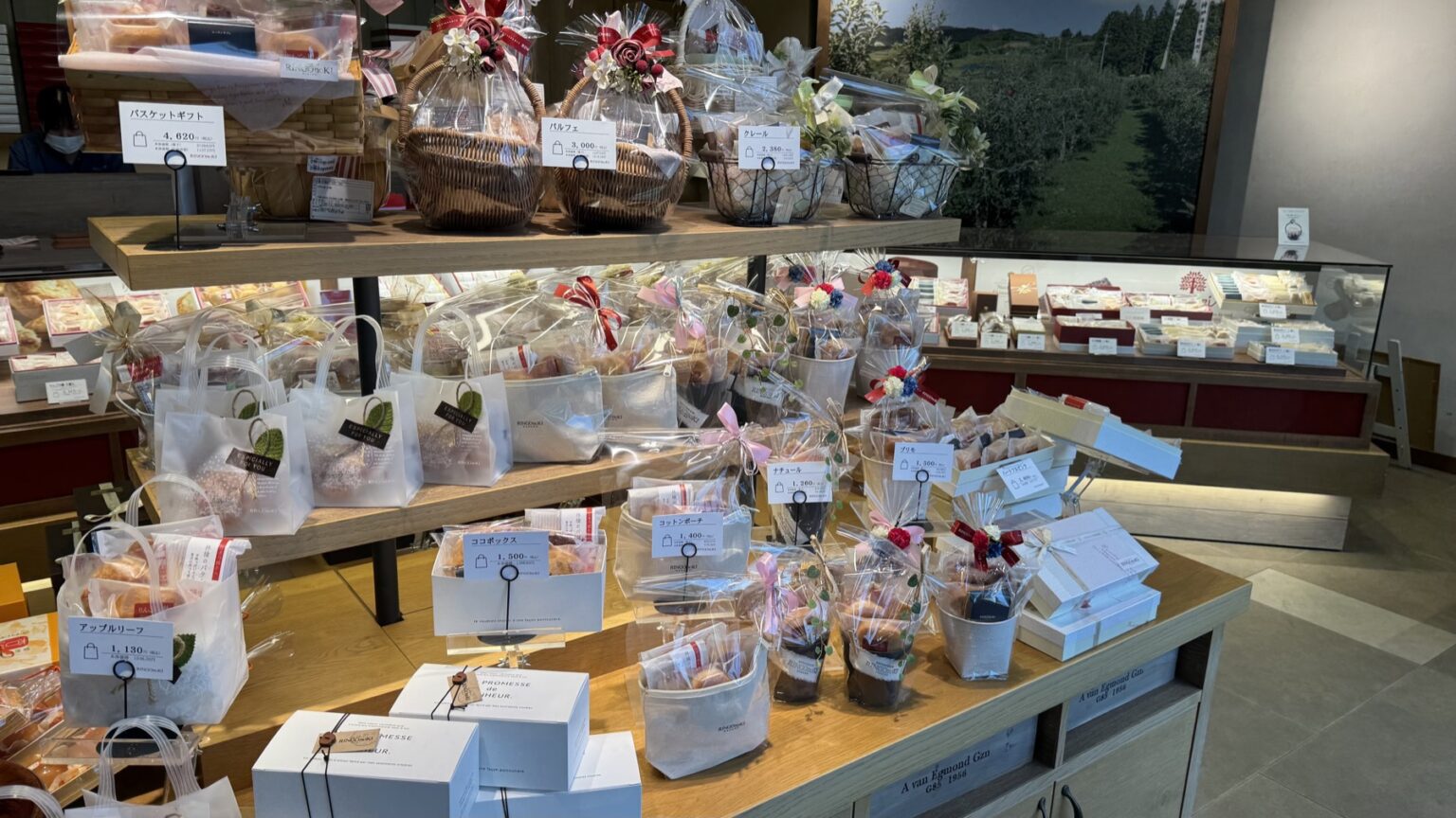 A display table of wrapped baked sweets and gift sets at Ringo no Ki patisserie in Chikuma, with cellophane bags of cookies and boxed confections in rows