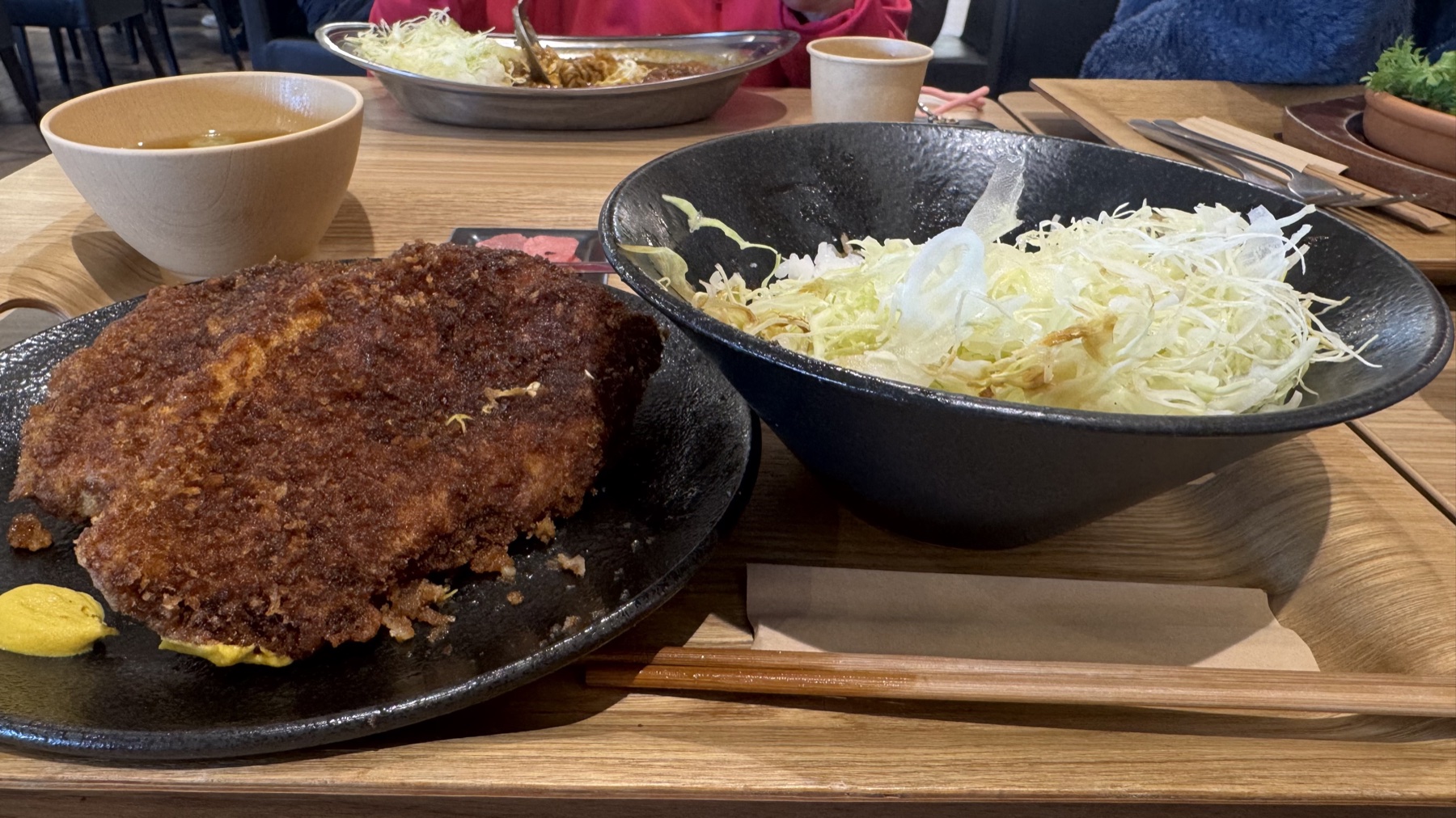 The Fujizakura-pork sauce katsudon set at Terrace Kitchen: a plate of breaded sauce cutlet with mustard, a large bowl of shredded cabbage and a bowl of miso soup, Tabi-no-Eki Kawaguchiko Base.