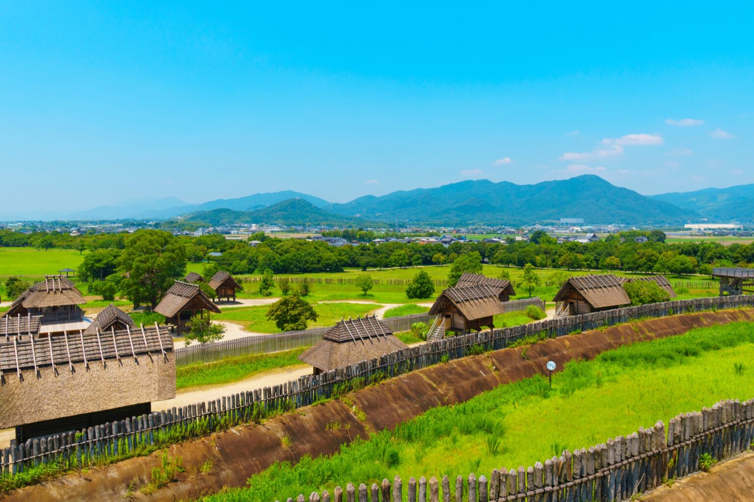 An elevated panoramic view over the reconstructed Yayoi-period moated village at Yoshinogari Historical Park in Saga