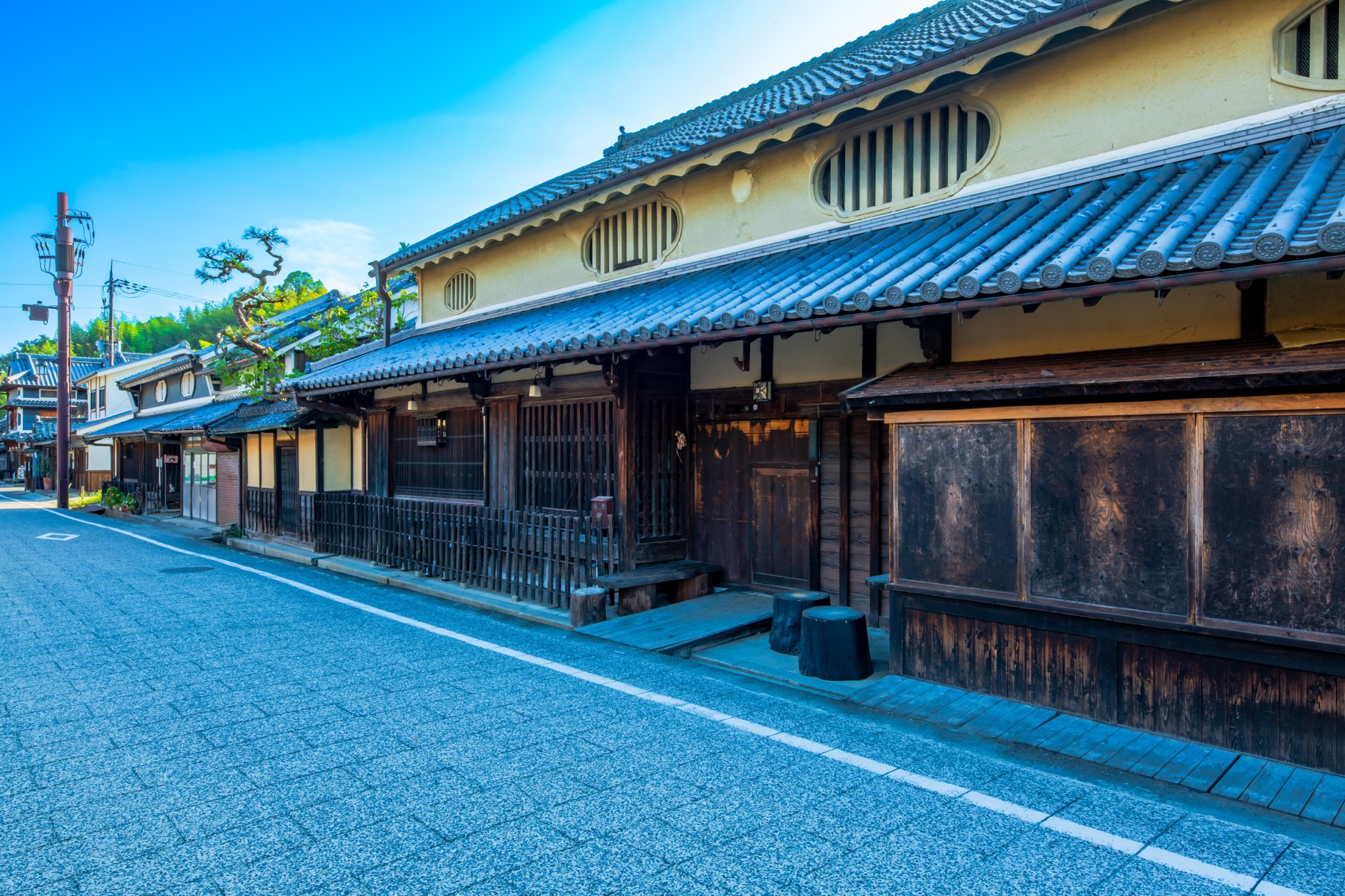 A large traditional house in Asuka village with cream plaster upper walls lattice windows wooden lattice frontage and a stone block by the entrance in the preserved Oka townscape