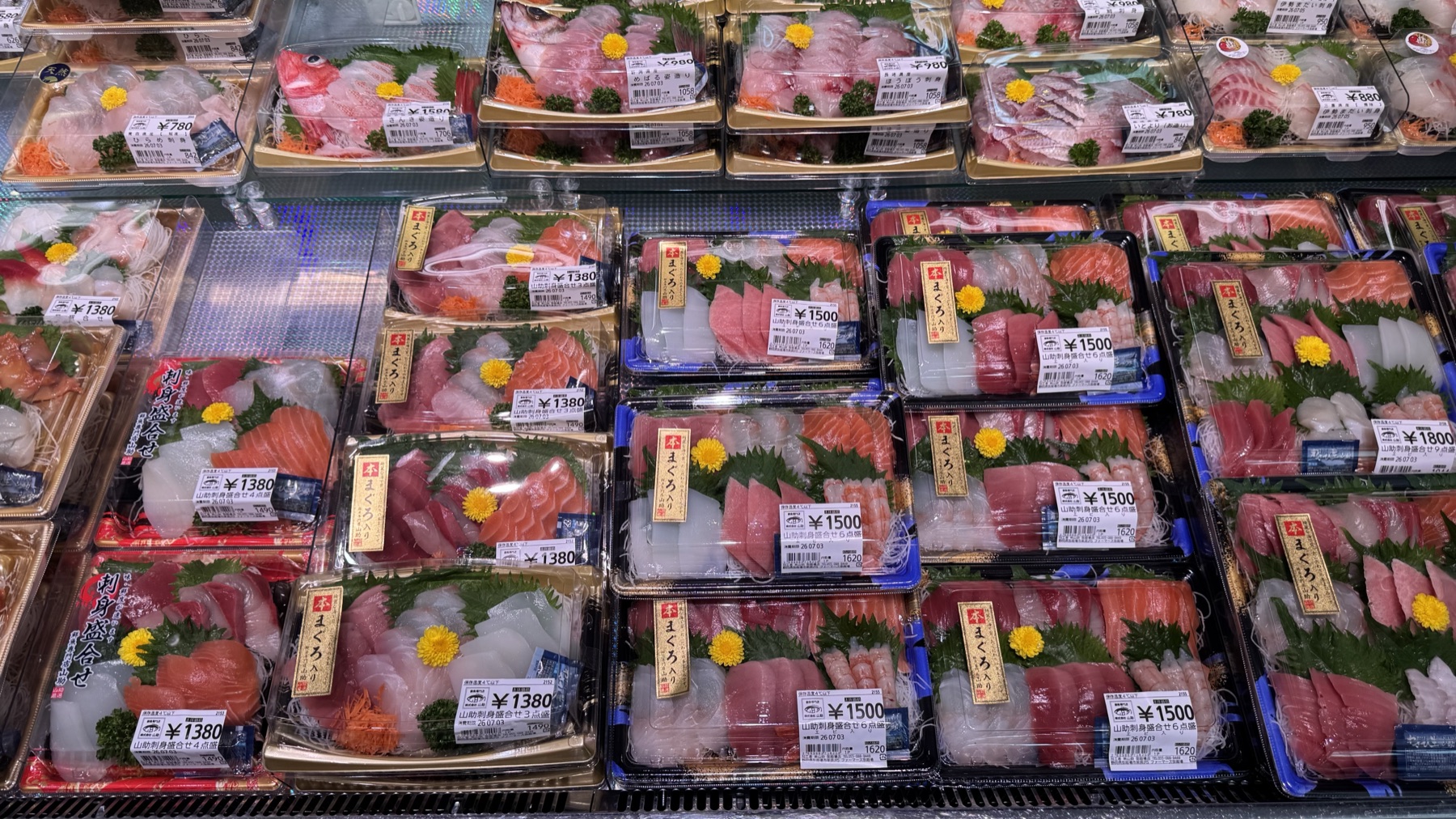 Trays of fresh sashimi and assorted fish platters priced from around 1,380 yen in the chilled case of the new fresh-fish section at Farmers Gotemba