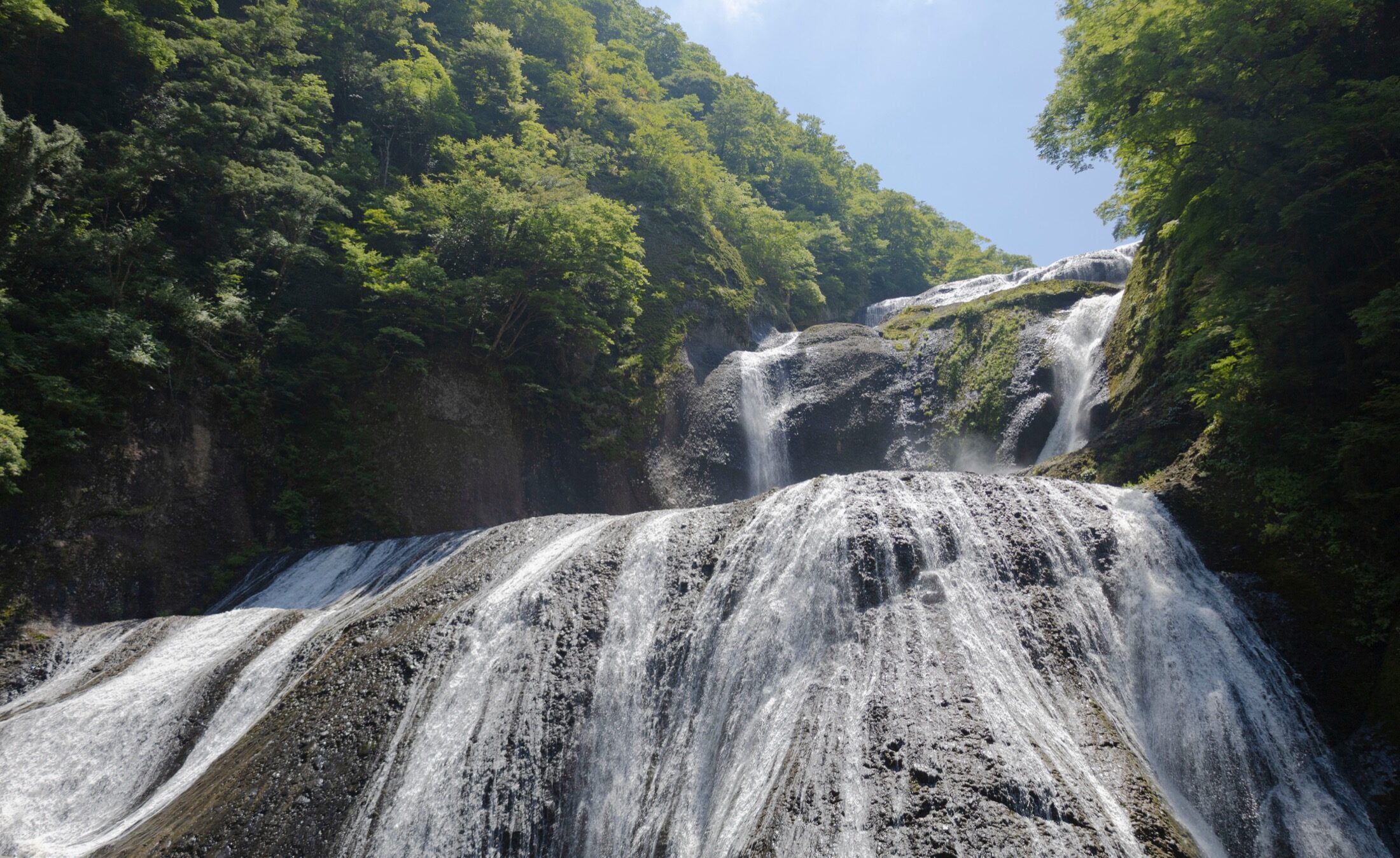 Fukuroda Falls in Ibaraki cascading 120 metres down broad rock tiers surrounded by deep green summer forest