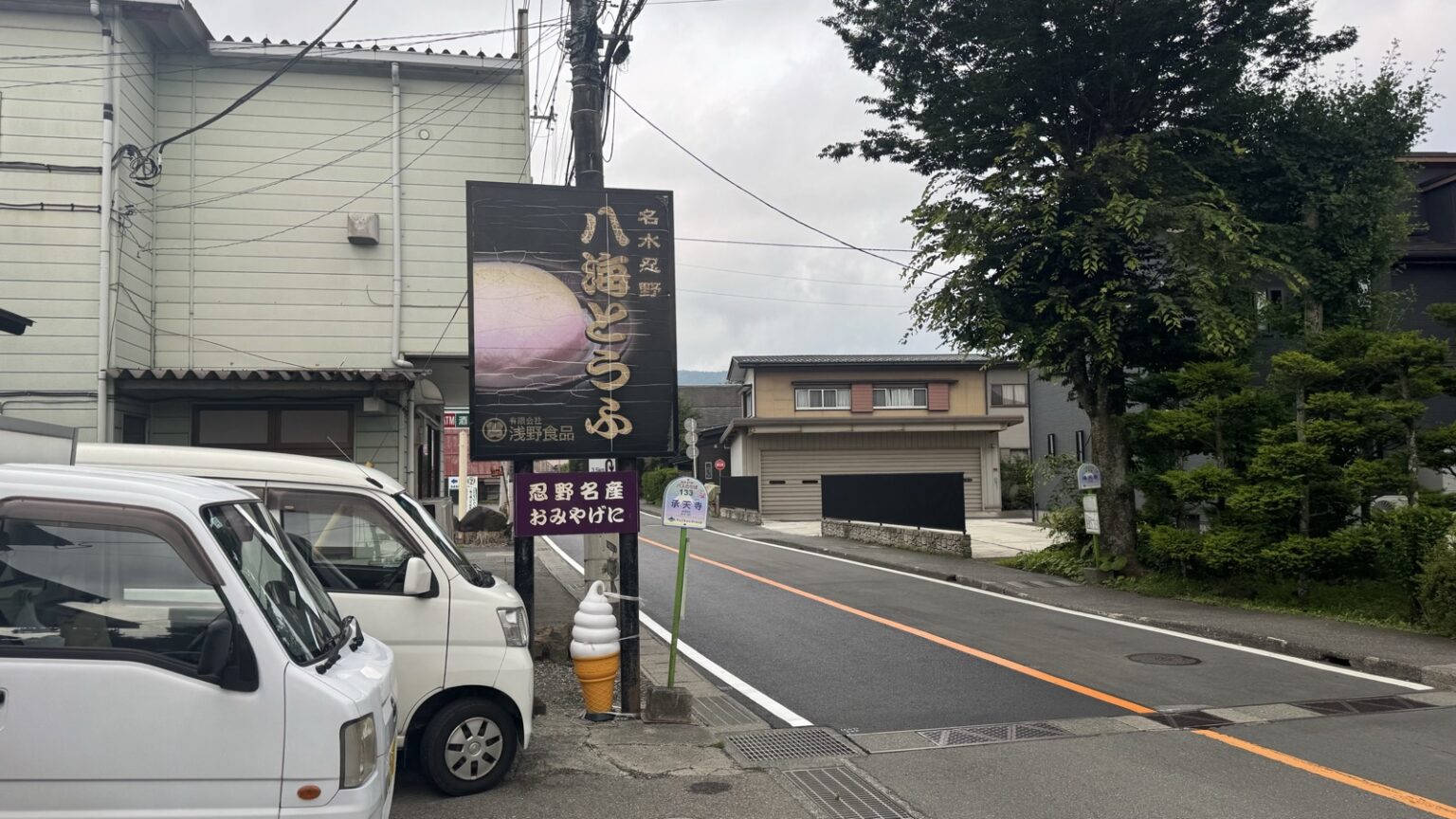 Hakkai Tofu signboard and soy-milk soft-serve display beside the Jotenji bus stop in Oshino