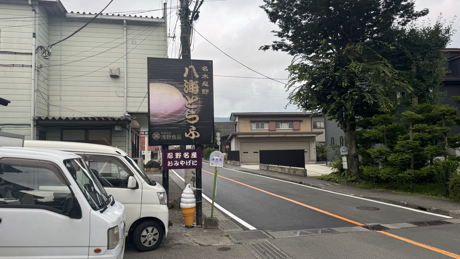 Hakkai Tofu signboard and soy-milk soft-serve display beside the Jotenji bus stop in Oshino