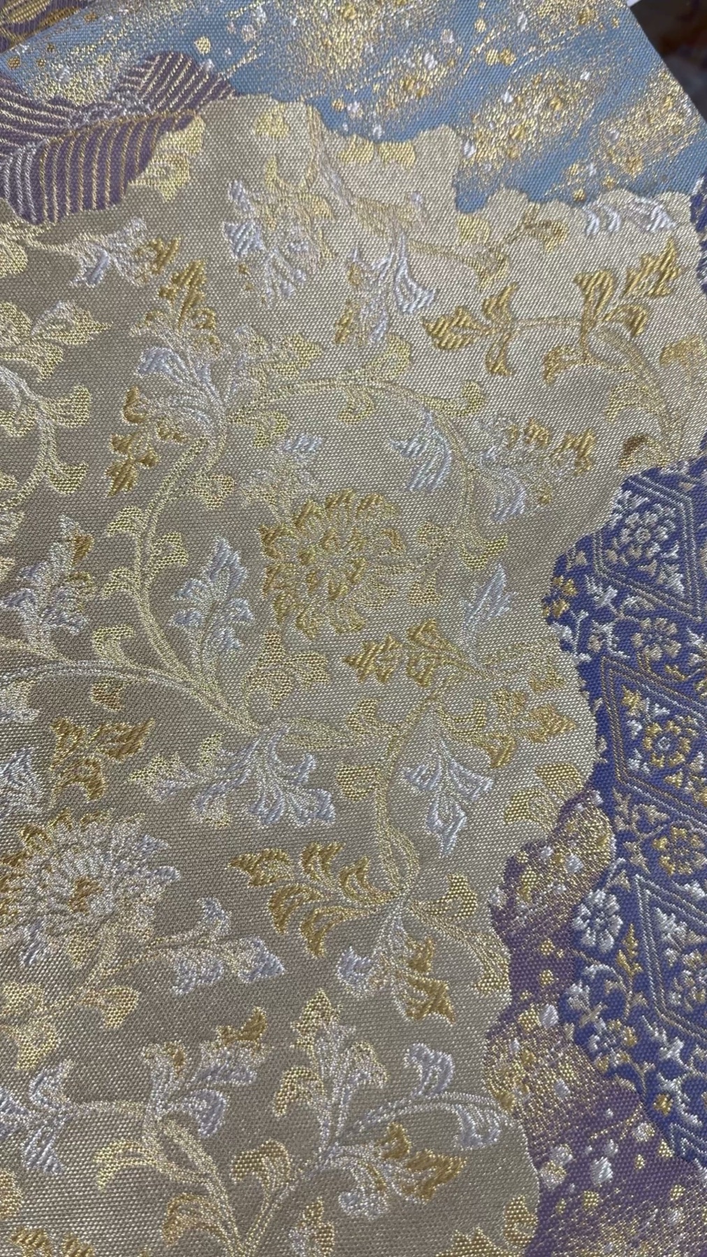 Close up of gold and silver brocade obi fabric with a woven floral chrysanthemum pattern among the secondhand kimono textiles at Off House Hachioji Owada, Tokyo
