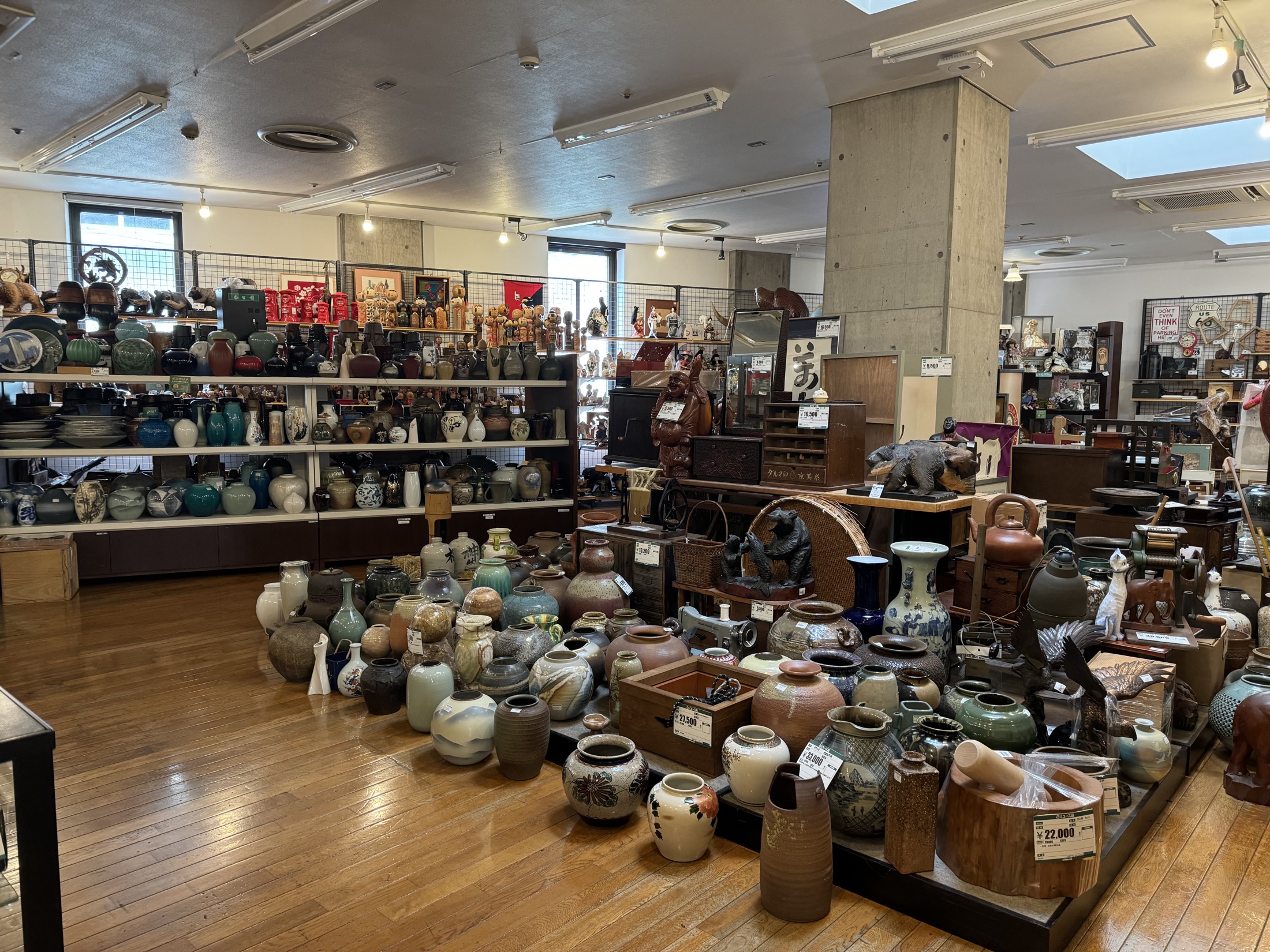 Rows of secondhand Japanese ceramic vases and tsubo storage jars covering the wooden floor of the antiques hall at the Hard Off and Off House reuse complex in Hachioji Owada, western Tokyo