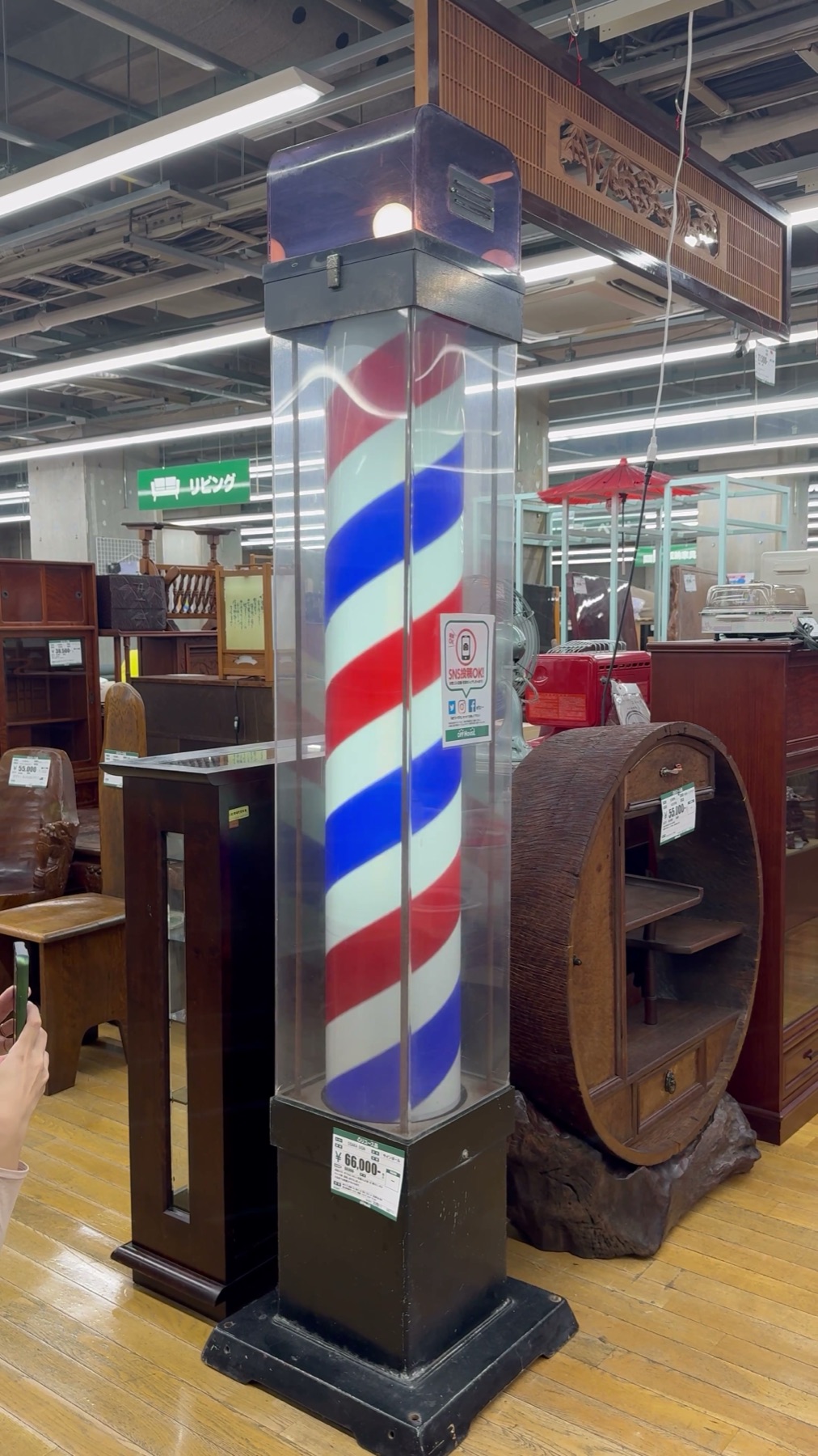 A tall vintage red white and blue barber pole priced at 66,000 yen standing in the used furniture living section of the Hard Off Hachioji Owada reuse complex in Tokyo