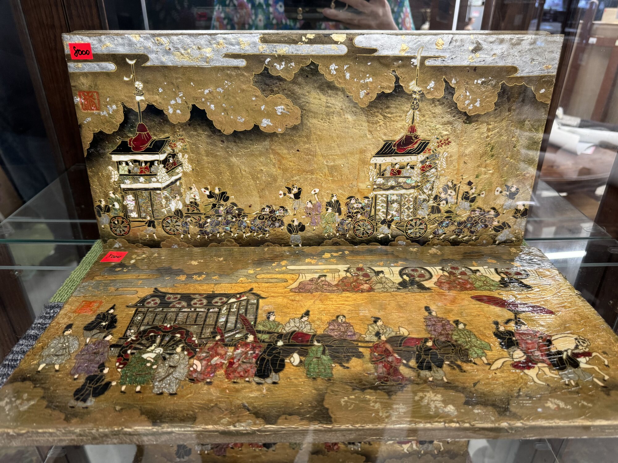 A gold-leaf lacquer panel depicting a townscape, displayed in a glass case at a Kyoto secondhand shop, the kind of one-off antique that turns up among everyday goods.