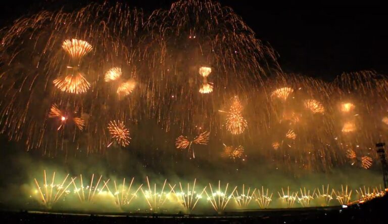 The Phoenix memorial fireworks at the Nagaoka Festival Grand Fireworks Show, a kilometres-wide wall of golden willow shells and rising comets over the Shinano River at night