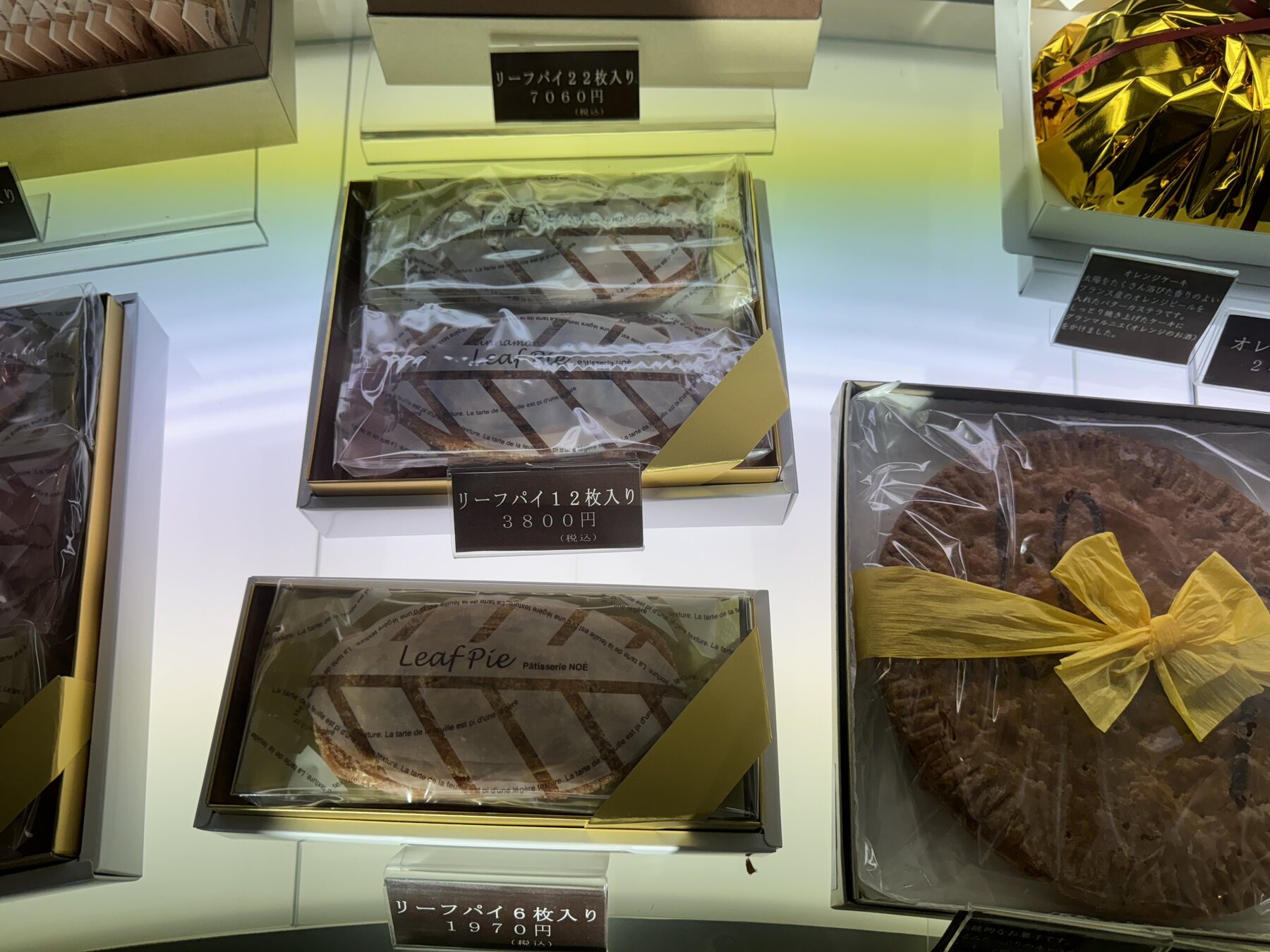 Boxed leaf-pie gift sets and a whole round pie shown with price tags at Okashinoie Noe in Nerima, Tokyo, in the shop's takeaway baked-goods and gift corner.