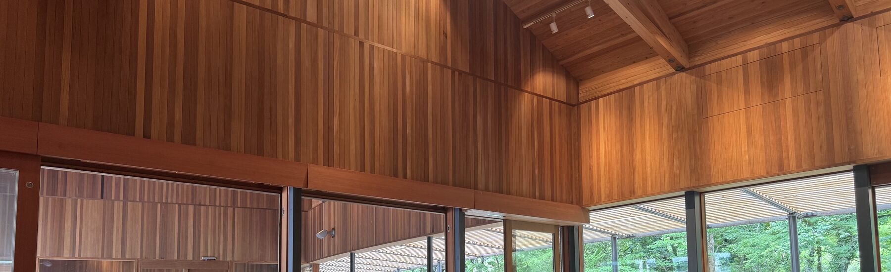 The soaring cedar ceiling and high wooden walls of the Naito Hiroshi-designed Toraya Kobo cafe above garden-view windows in Gotemba, Shizuoka