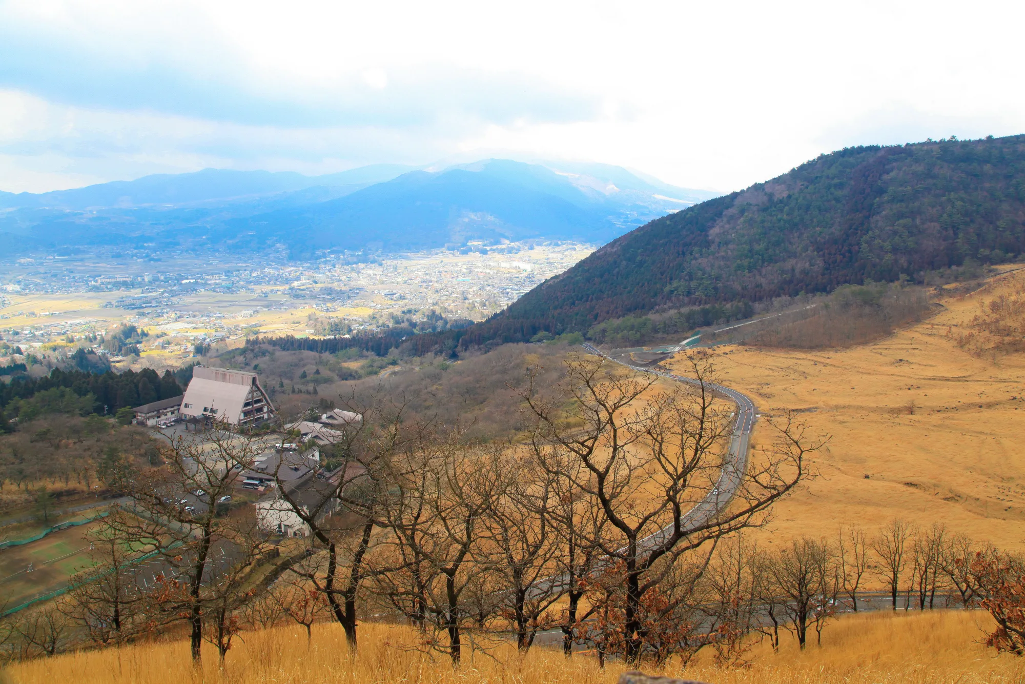 The Aso Panorama Line winding across green volcanic grassland, Kumamoto