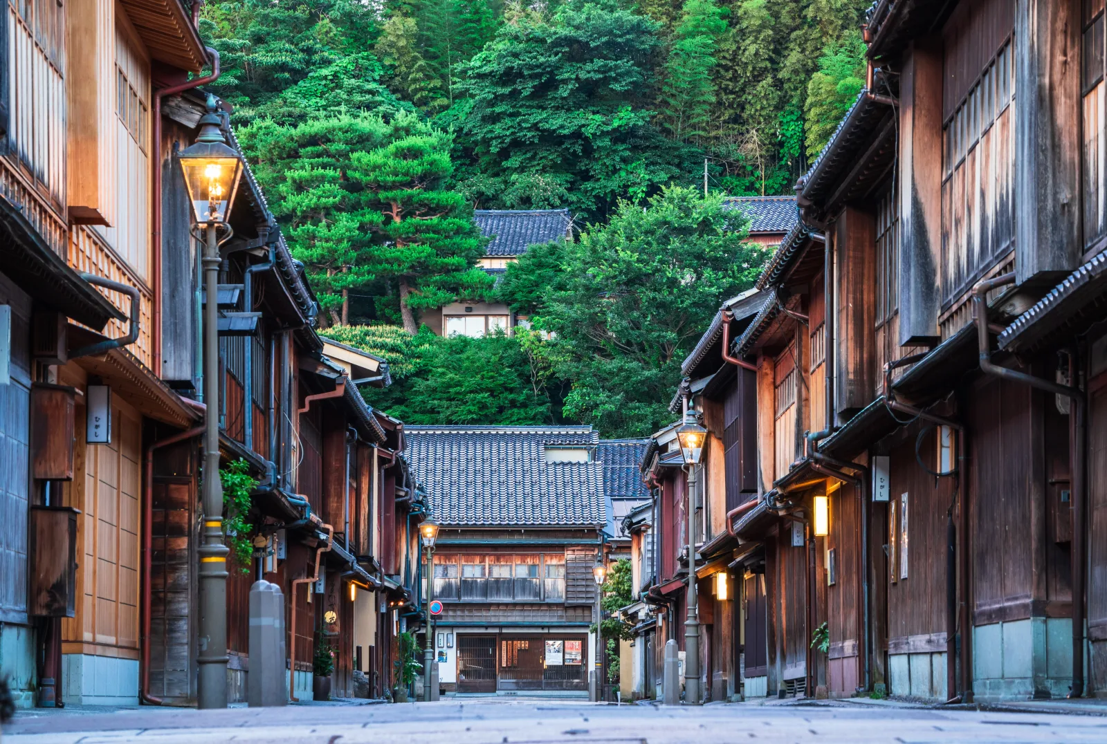 The Higashi Chaya teahouse district in Kanazawa with wooden lattice facades lining the stone-paved street under a clear sky