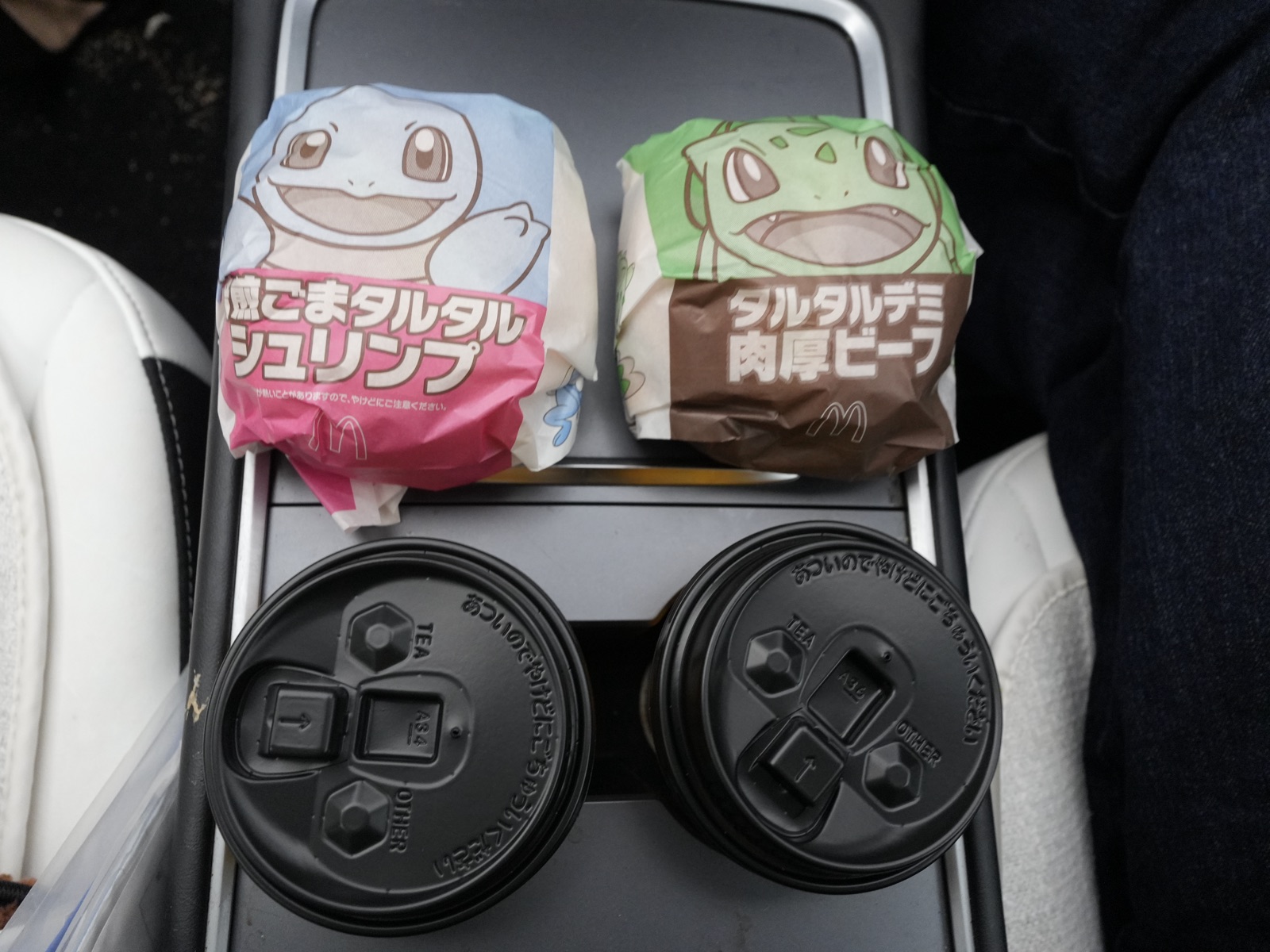 Two McDonald's Japan Pokemon Summer Mac burgers and drinks in a car