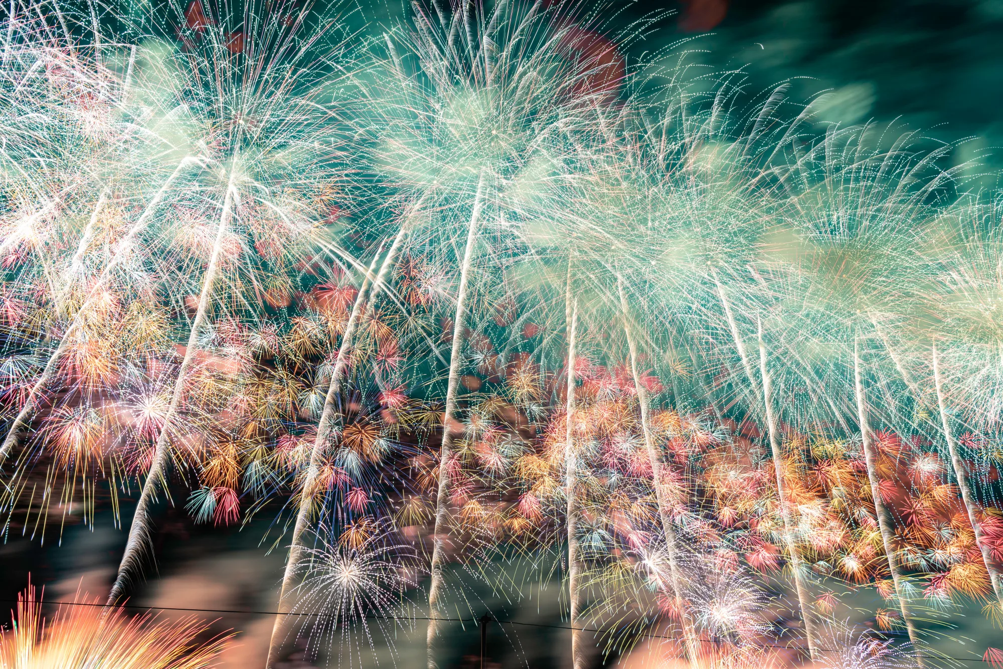 Wide starmine fireworks display reflected in the river at night