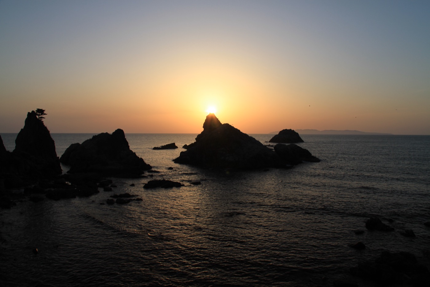 Jagged sea-stack rocks of the Sasagawa Nagare coast silhouetted against a golden sunset over the Sea of Japan, Murakami, Niigata
