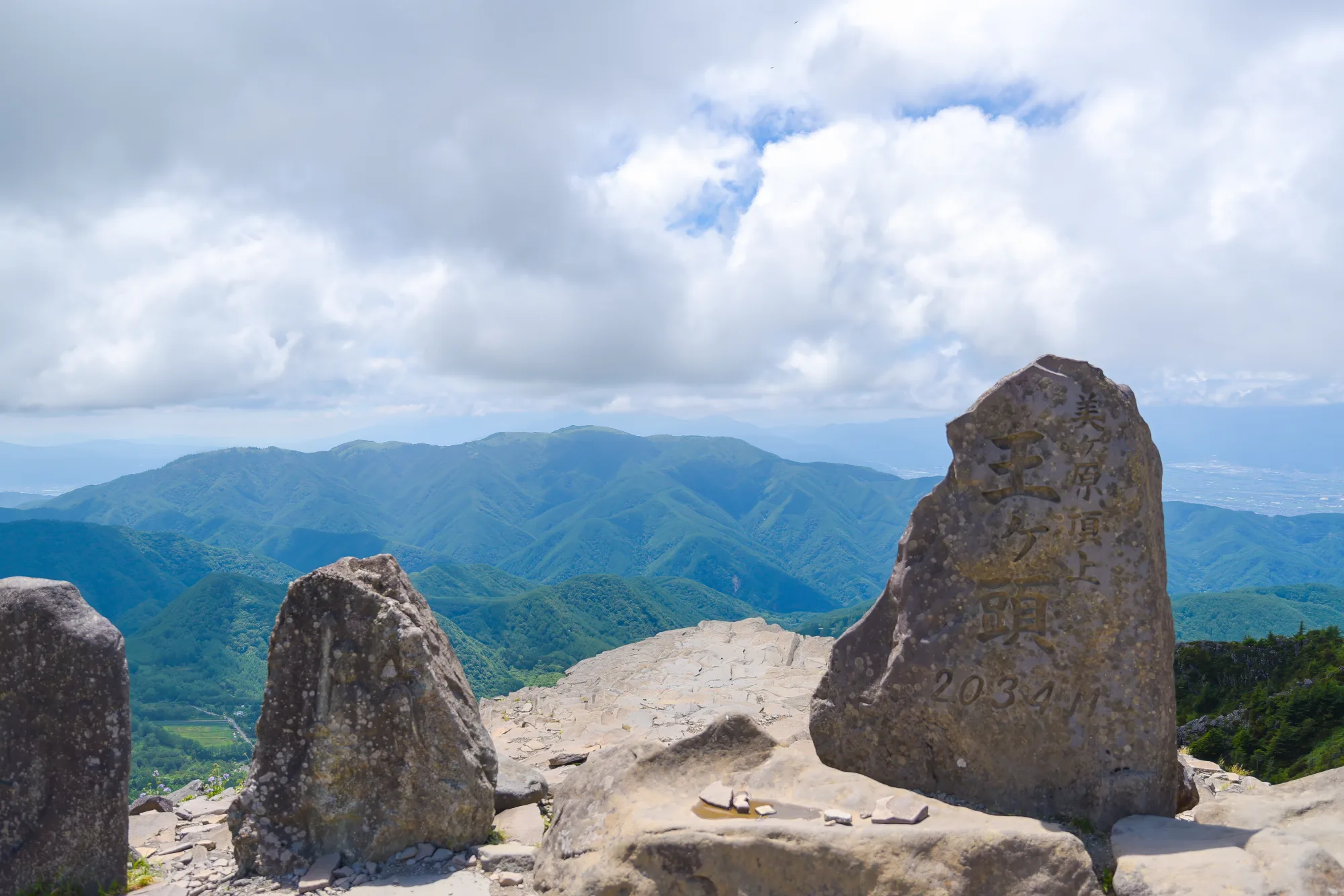 The summit marker at Ogato the highest point of the Utsukushigahara plateau under a summer sky