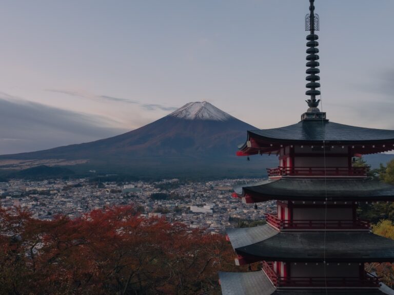 Chureito Pagoda and a snow-capped Mt Fuji at first light, with autumn maples below