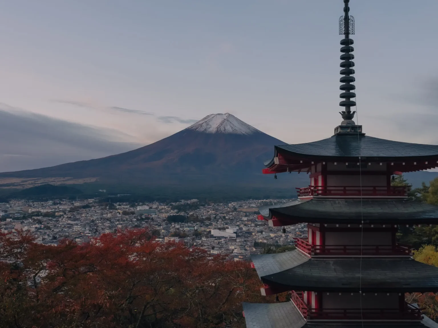 Chureito Pagoda with Mount Fuji behind it at autumn sunrise, the snowcap lit pink