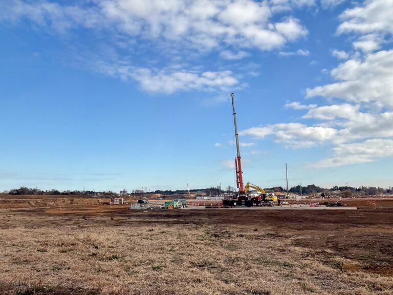 The GREEN×EXPO 2027 site at the former Kamiseya Communications Facility in Yokohama, still bare ground with a single crane, December 2025
